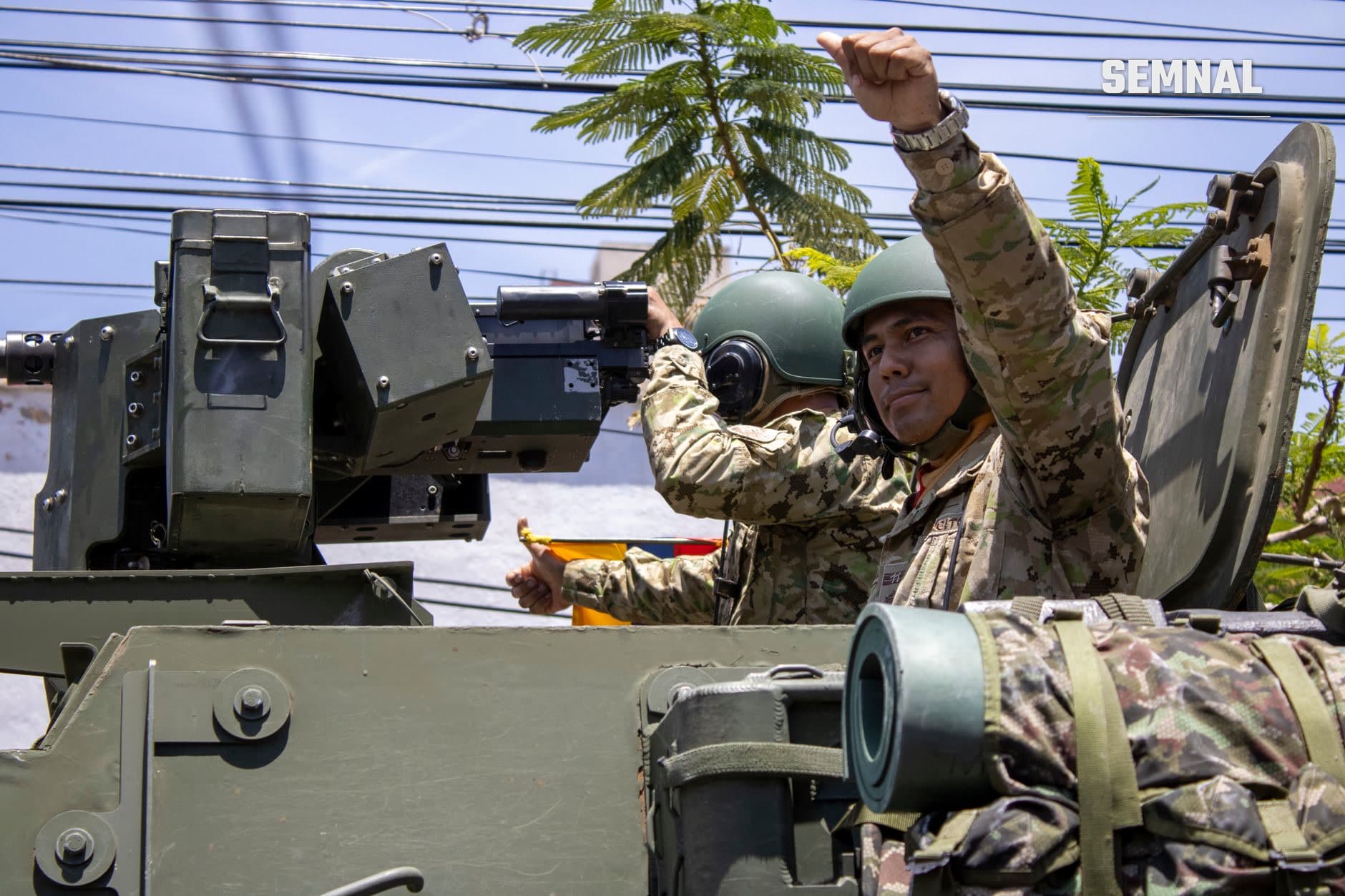 Militari taiwanezi în uniforme de camuflaj operând sisteme de armament pe vehicul blindat, cu un soldat ridicând pumnul într-un gest de determinare și rezistență.