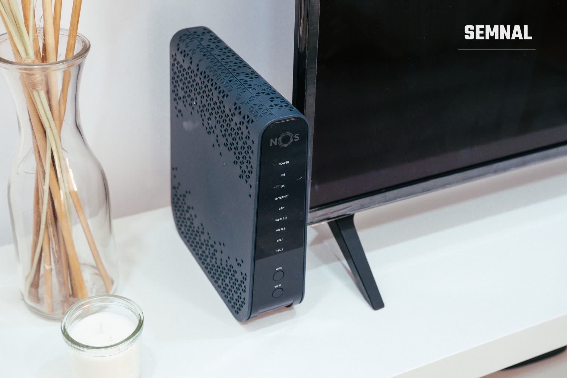 Router wireless NOS5 cu antene WiFi și indicatori luminoși pe birou, echipament utilizat pentru securizarea și gestionarea rețelei WiFi de acasă.