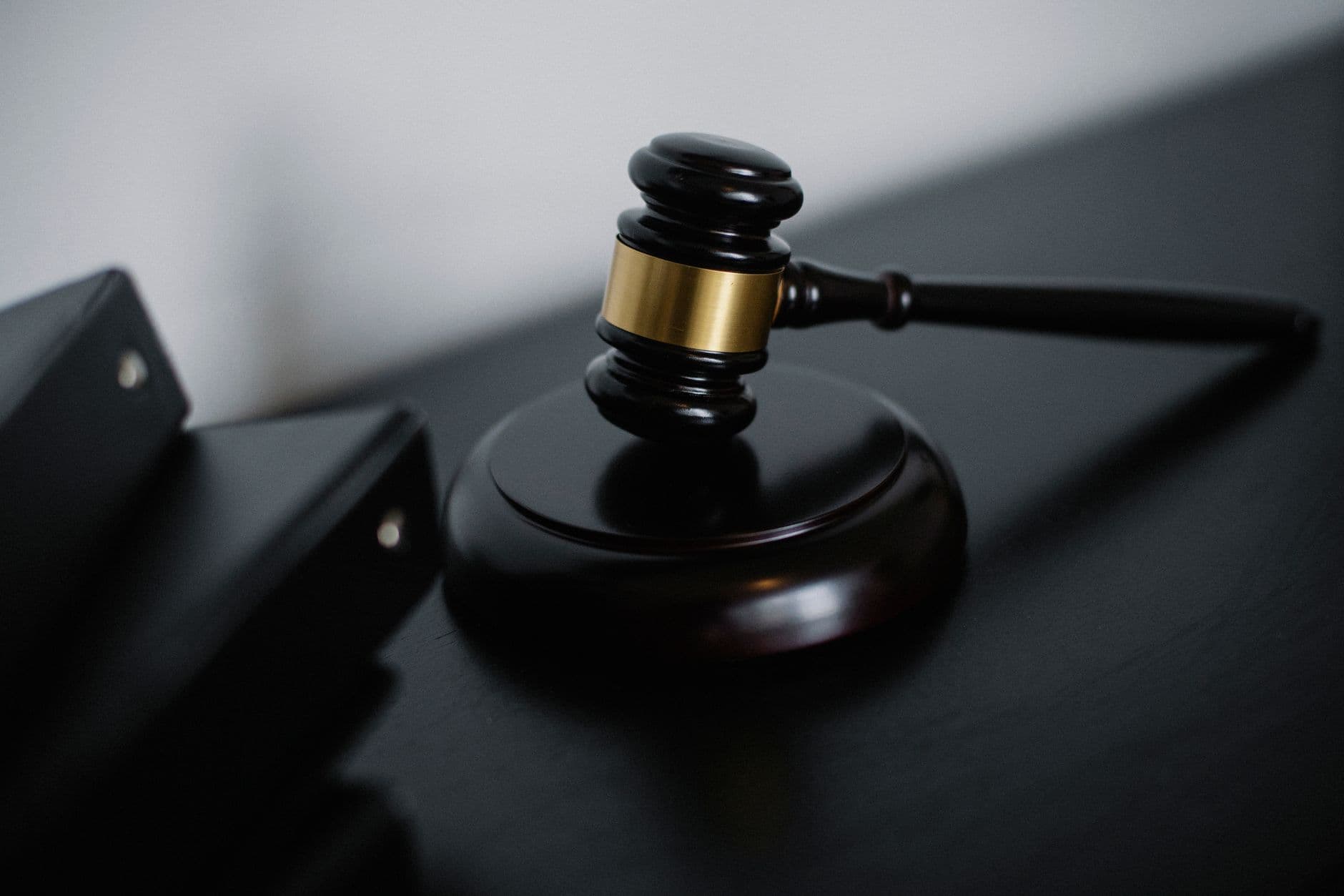 Ciocan de judecător din lemn negru cu bandă aurie pe moară de judecată, simbolizând autoritatea legală și procesele de succesiune în dreptul moștenirii românești