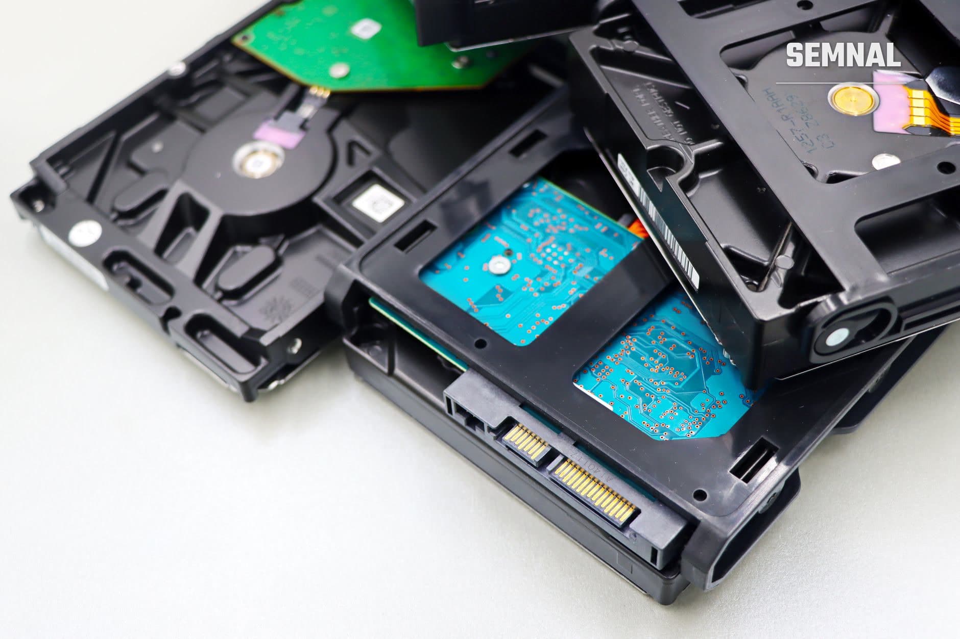 Detaliu intern al unui hard disk cu plăci electronice albastre și verzi, connector SATA și componente de stocare a datelor pentru ilustrarea backup-ului digital (Foto: Marta Branco / Pexels)