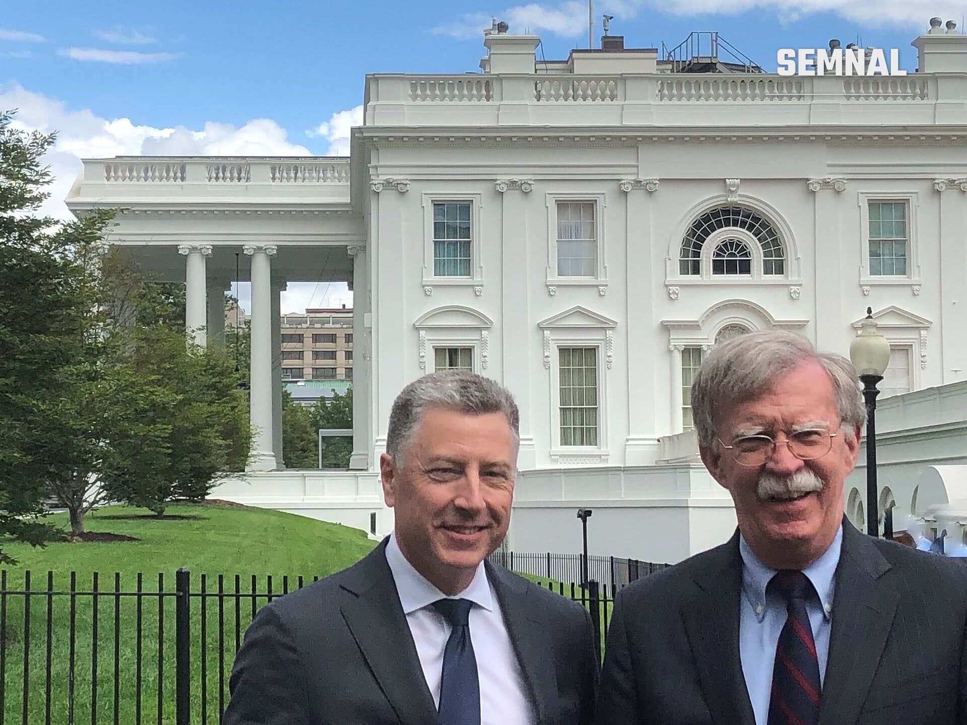 Kurt Volker, fost ambasador al Statelor Unite pe lângă NATO, fotografiat în prim-plan alături de un alt oficial în fața Casei Albe, pe fondul clădirii cu coloane albe și gazon verde. (Foto: Office of U.S. National Security Advisor)