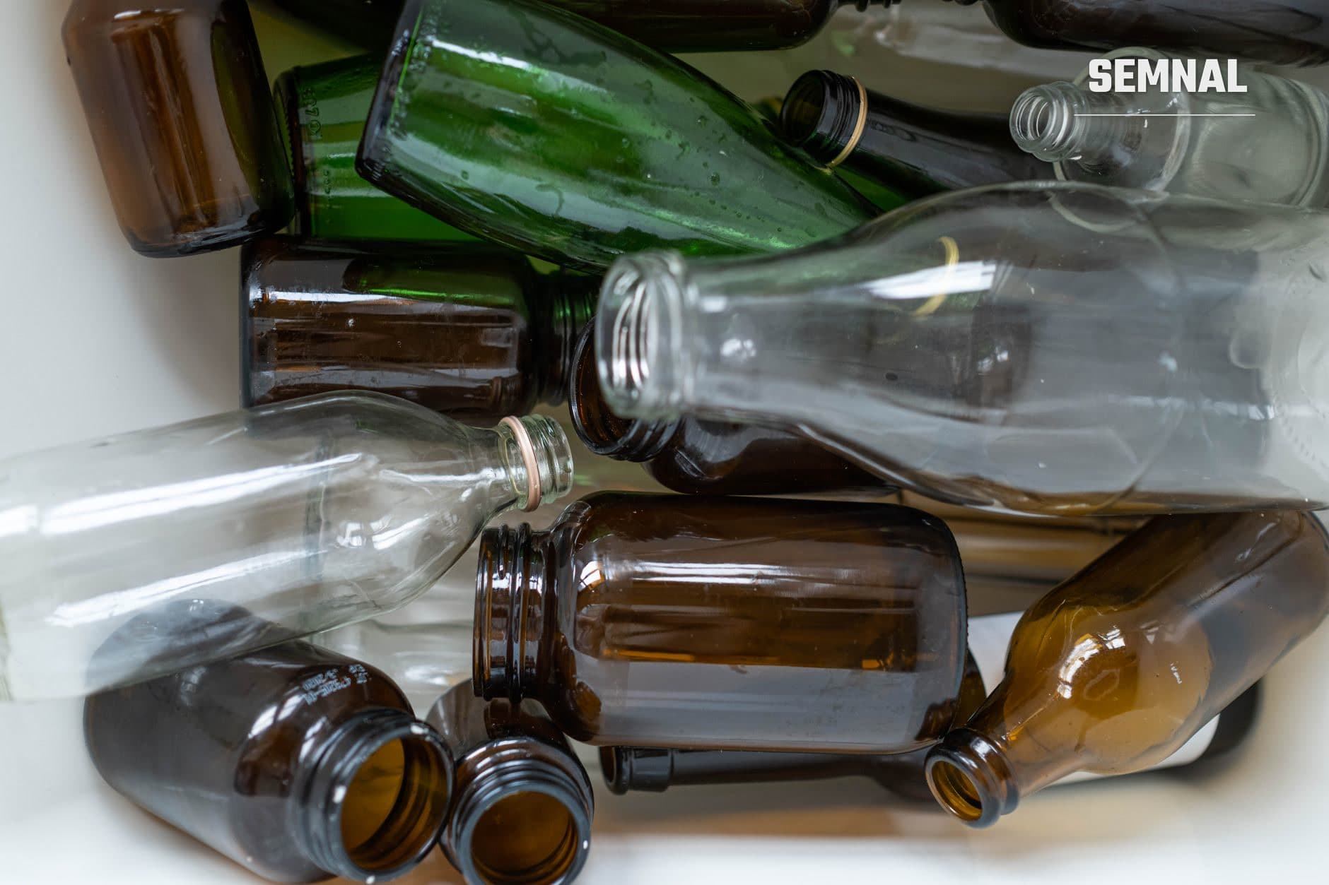 Colecție de sticle și borcane goale în diverse culori și dimensiuni, reciclabile, dispuse pentru colectare și reutilizare conform sistemului de garanție pe ambalaje. (Foto: Ron Lach / Pexels)