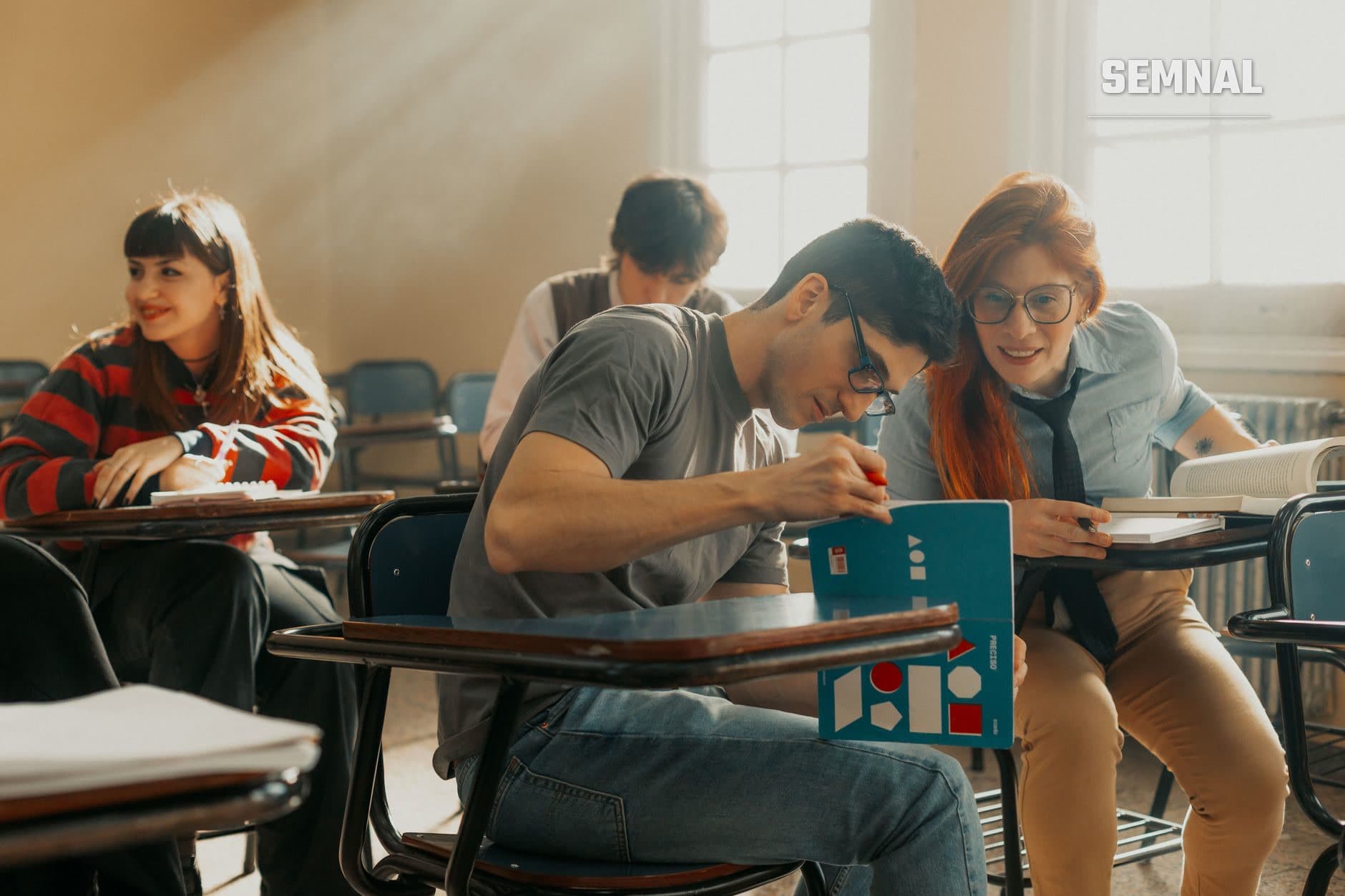 Grup de patru tineri în sala de clasă care lucrează colaborativ la un proiect cu material didactic colorat, ilustrând reintegrarea educațională și activitatea de grup în contexte școlare reformate. (Foto: Gera Cejas / Pexels)