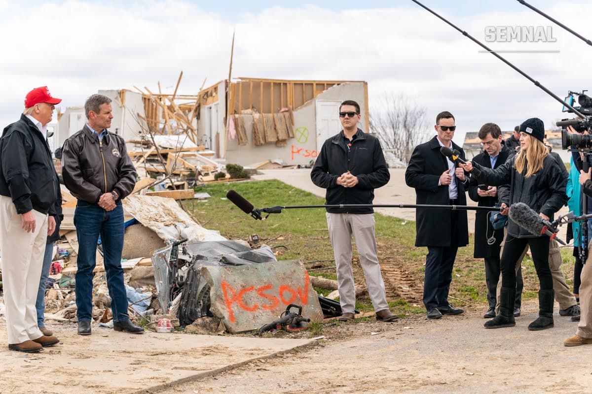 Bill Lee, guvernatorul Tennessee, la o conferință de presă în fața unei zone cu construcții avariate, purtând jachetă neagră și ochelari de soare, înconjurat de oficiali și echipa media. (Foto: The White House from Washington, DC)