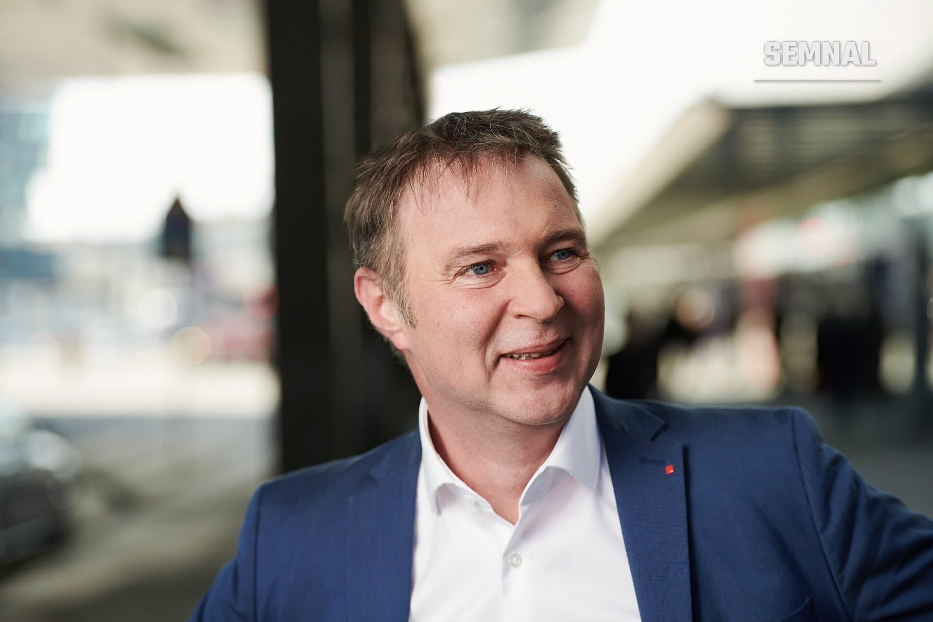 Andreas Babler, vicecancelarul Austriei, în portret de presă purtând costum albastru și cămașă albă, zâmbind la cameră. (Foto: Team Basis)