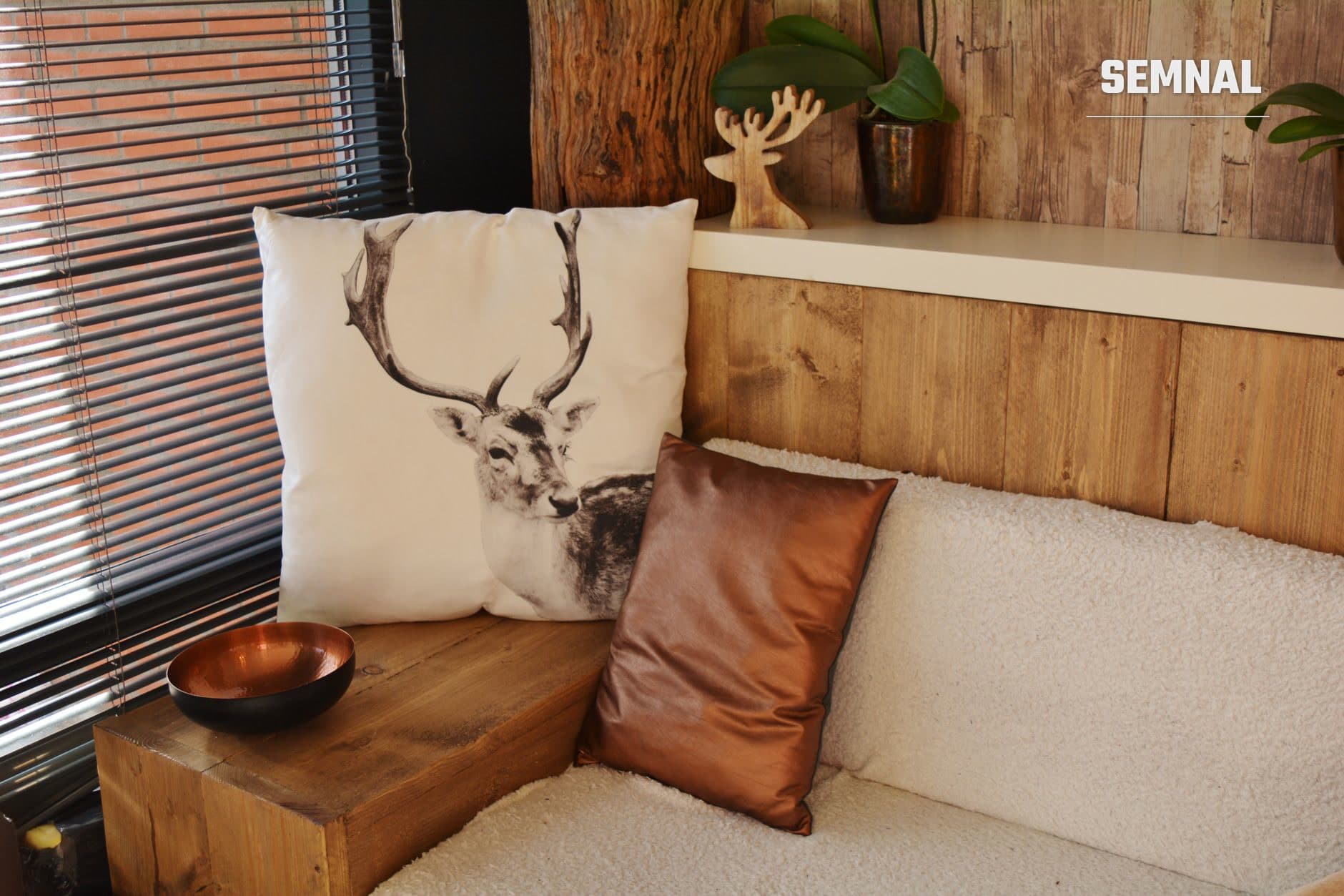 Colț de cameră mică amenajat cu canapea bej și perne decorative, masă de lemn reconfigurat, plante în ghivece și decorații minimaliste într-un stil de design interior accesibil și sustenabil. (Foto: Pixabay / Pexels)