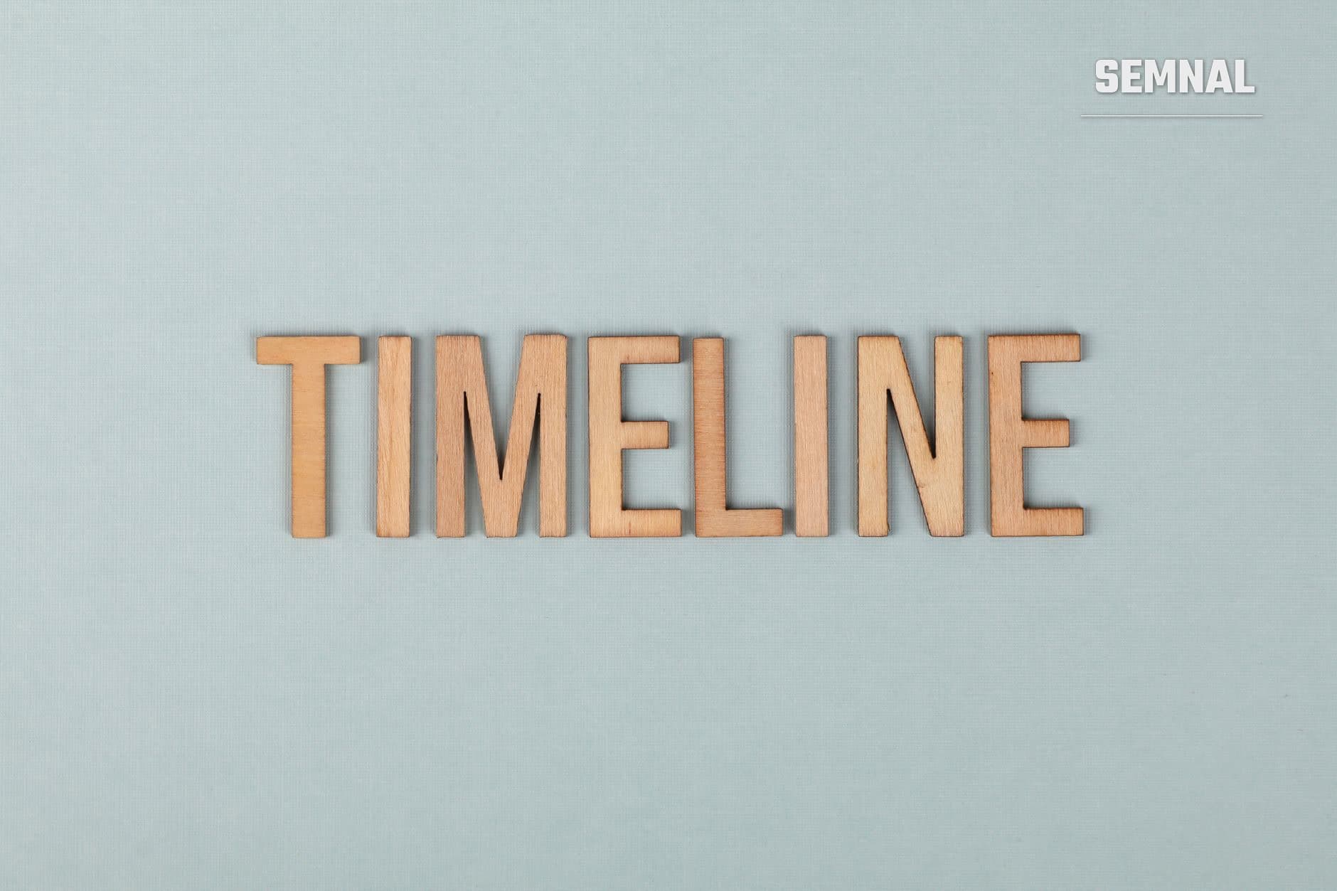 Cuvântul "TIMELINE" compus din litere de lemn pe fundal gri, ilustrând conceptul de durată și succesiune temporală în formarea obiceiurilor. (Foto: Ann H / Pexels)