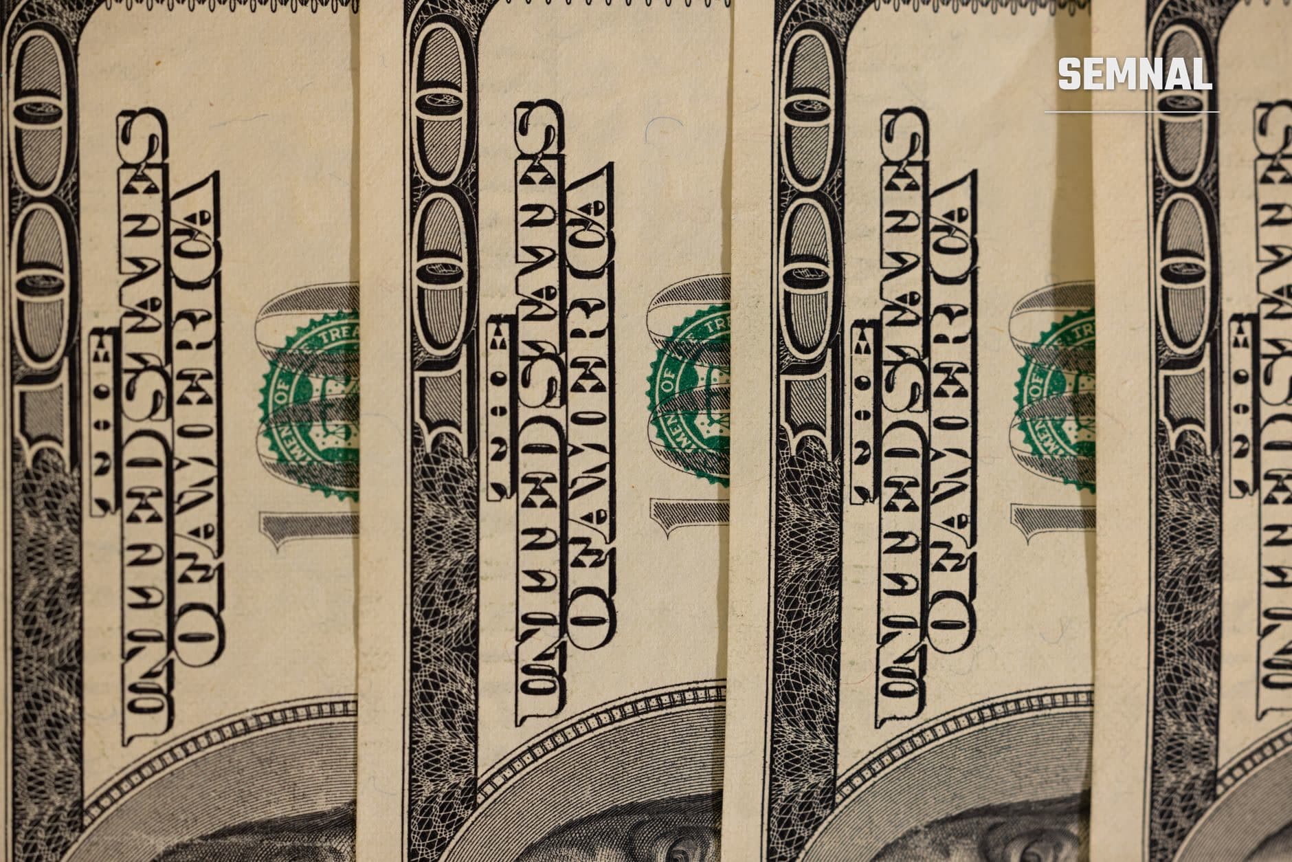 Detaliu de mai multe bancnote de dolar american suprapuse, arătând textul oficial și sigiliul verde al Trezoreriei, ilustrând contextul financiar și monetar al unei amenzi bancare federale. (Foto: Engin Akyurt / Pexels)