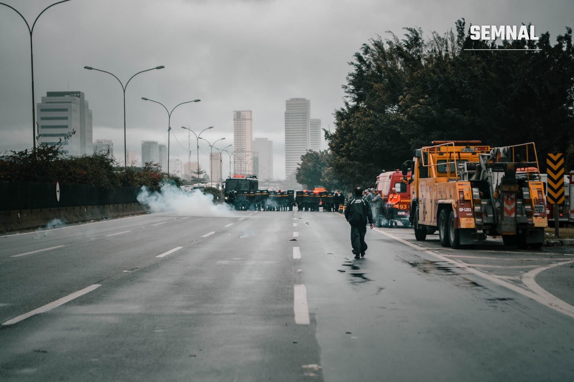 Forțe de poliție și vehicule de intervenție orange blocând autostrada în Tirana pe fondul confruntărilor violente cu protestatarii, cu gaz lacrimogen vizibil pe carosabil. (Foto: Joel Santos / Pexels)