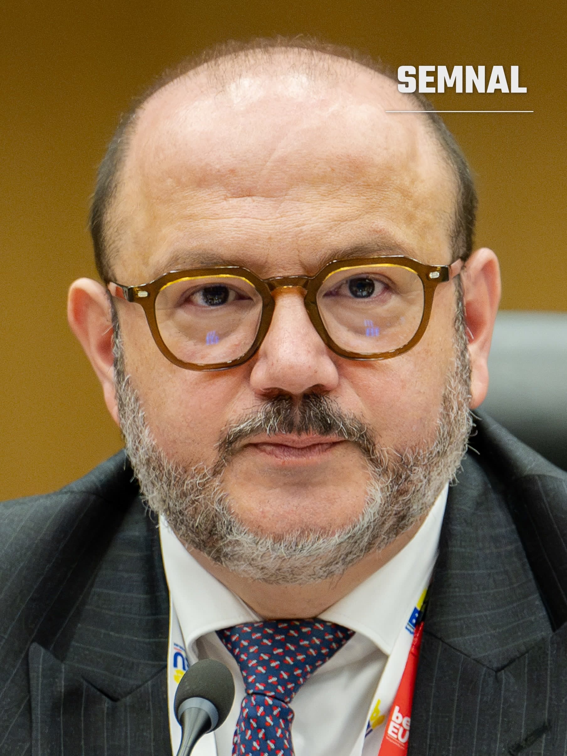 Bernard Quintin, ministrul belgian de interne, în fața unui microfon, cu ochelari cu rame maro și costum închis la culoare. (Foto: Belgian Presidency of the Council of the EU 2024 from Belgium)