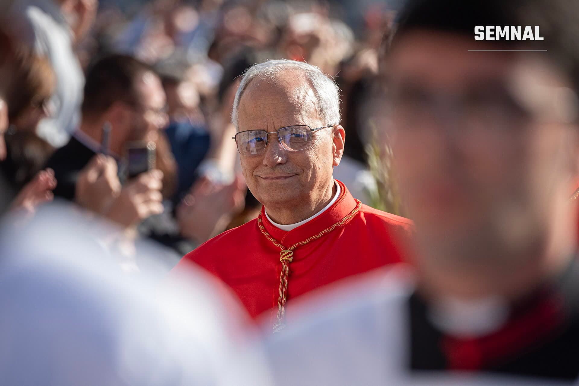 Papa Leon al XIV-lea zâmbind, cu ochelari și veșmânt roșu cu cordon auriu, într-o mulțime de oameni. (Foto: Ricardo Perna (AIIC))