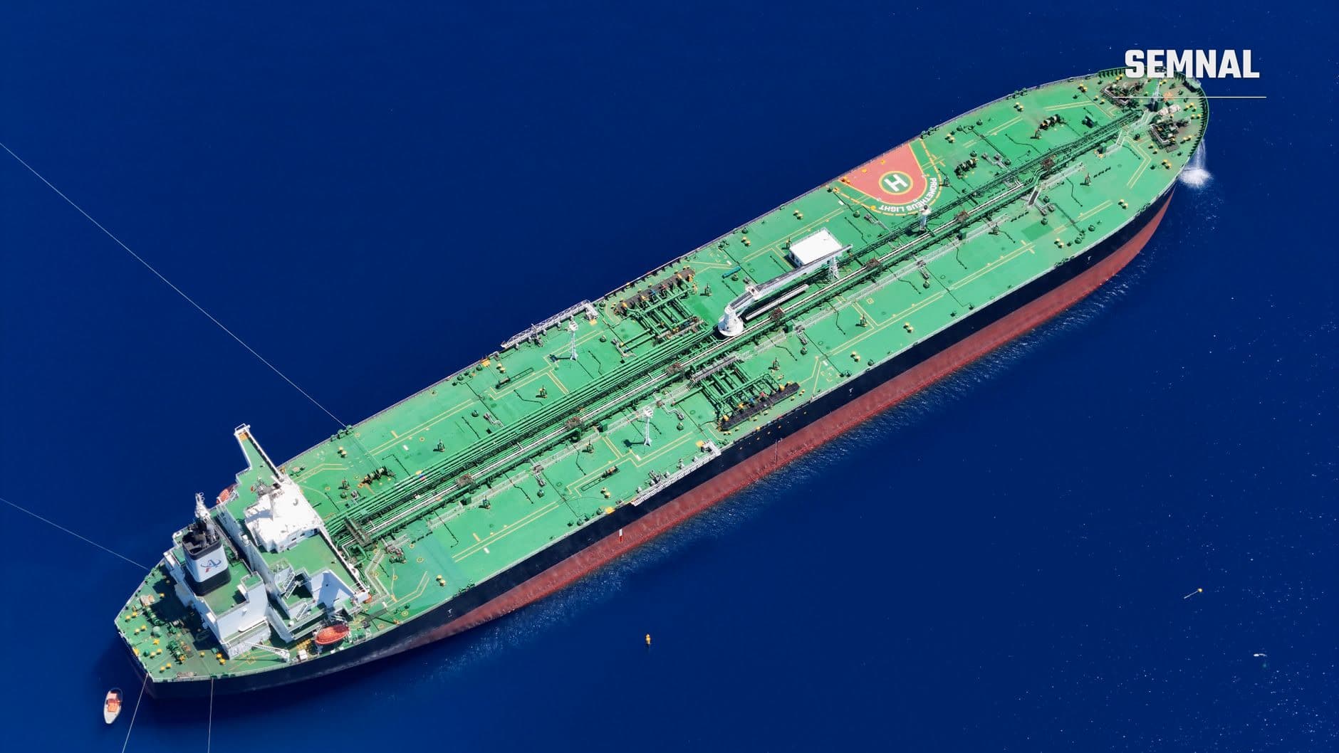 Vedere aeriană a unei petroliere mari, cu punte verde și corp roșcat, pe o mare albastră (Foto: DeLuca G / Pexels)