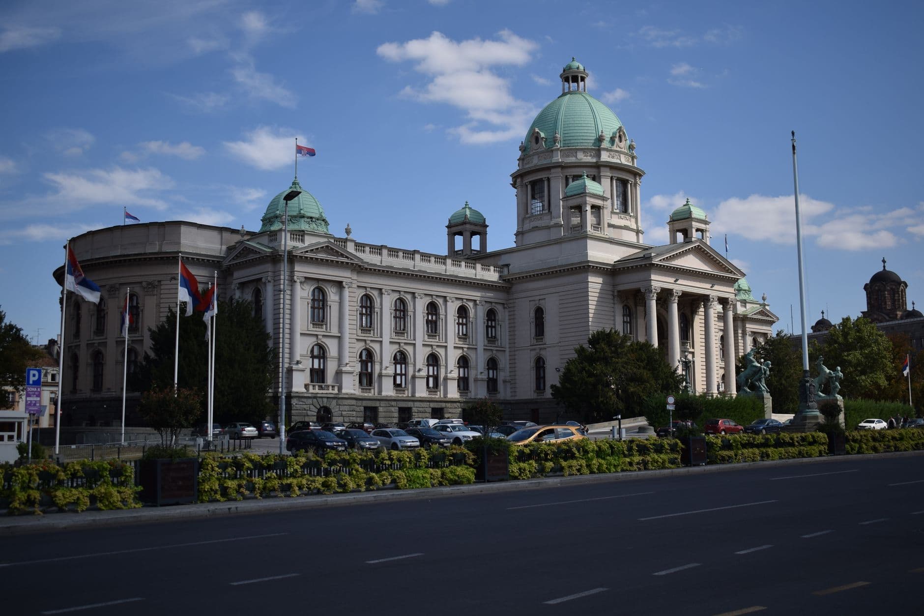 Clădirea Adunării Naționale a Serbiei din Belgrad, cu cupolă verde și steaguri sârbești în față (Foto: Evrim Kantar / Pexels)