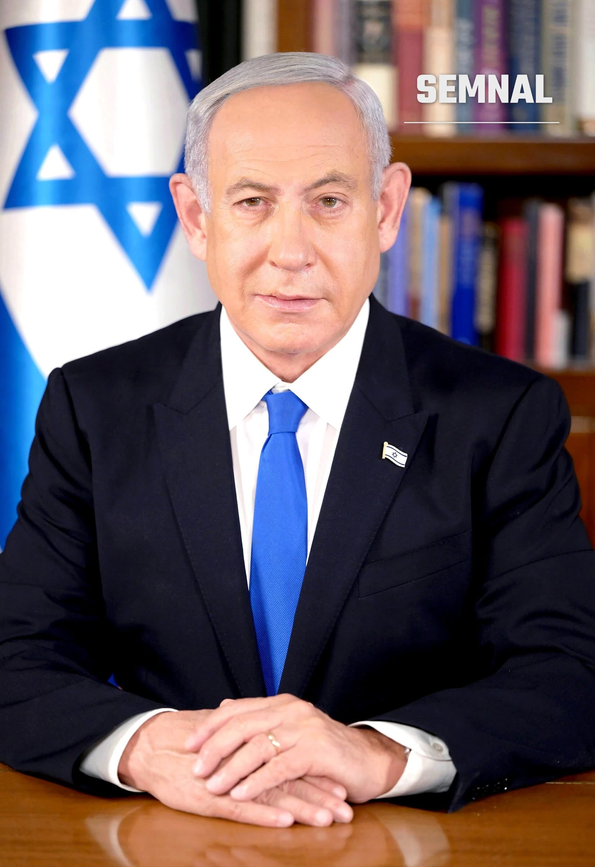 Benjamin Netanyahu, premierul Israelului, în costum închis, cu cravată albastră, în fața steagului Israelului și a unei biblioteci. (Foto: Avi Ohayon)