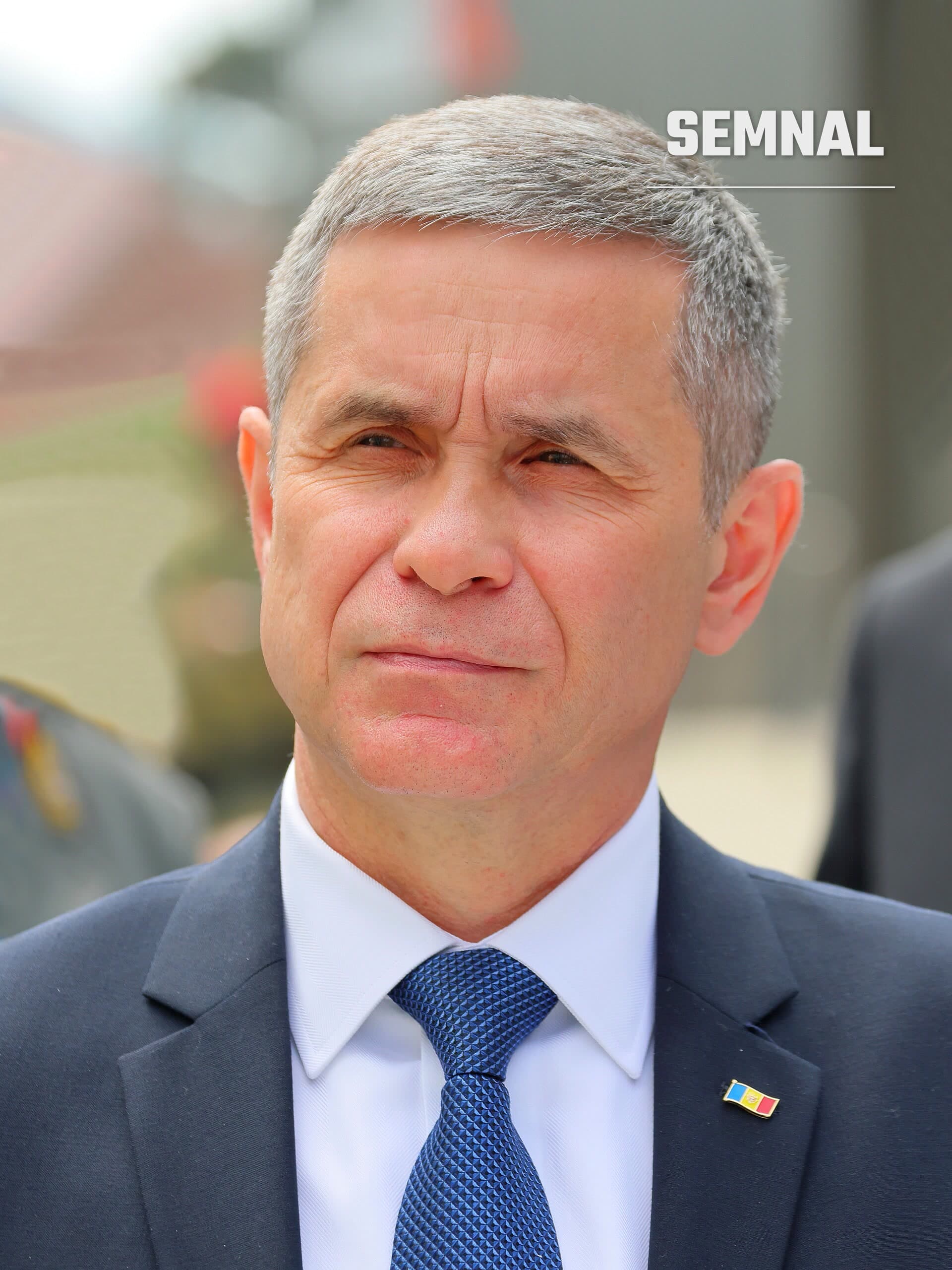 Anatolie Nosatîi, ministrul apărării, într-un costum bleumarin, cu cămașă albă, cravată albastră și insigna cu steagul Moldovei pe rever. (Foto: C.Stadler/Bwag)