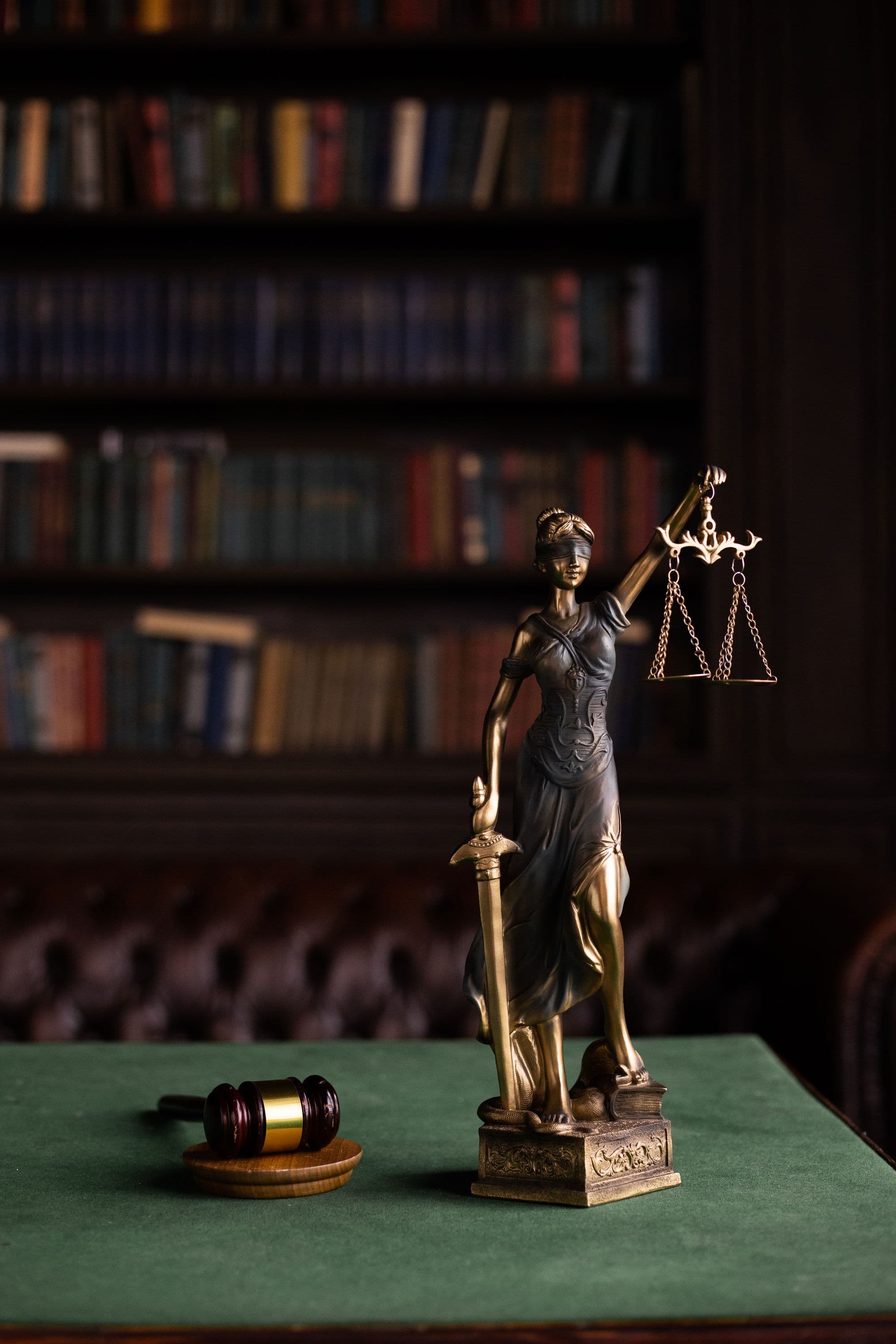 Statuetă a Justiției alături de un ciocănel de judecător, imagine ilustrativă