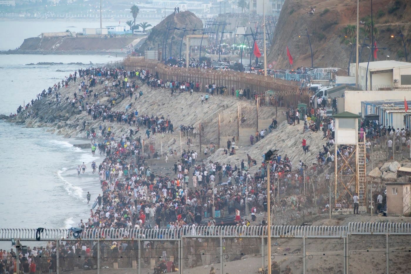 Mii de persoane pe digul de la Tarajal, la frontiera dintre Maroc și enclava spaniolă Ceuta, lângă gardul de frontieră și un turn de observație