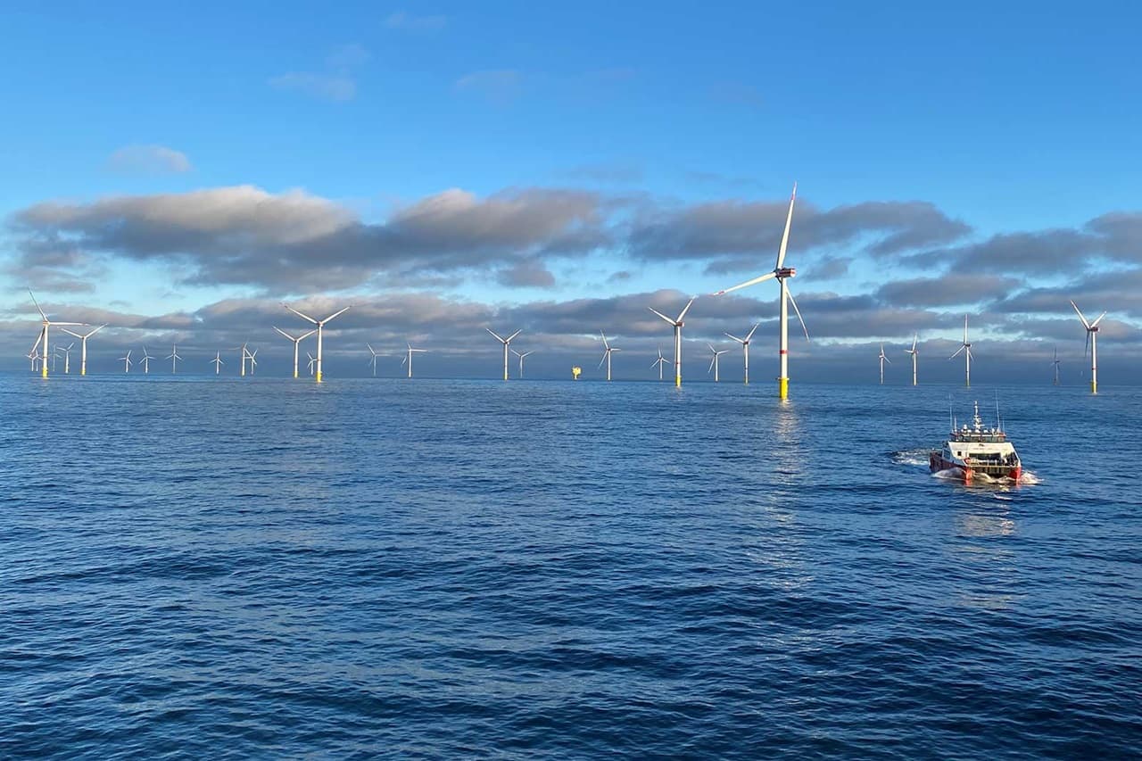 Turbine eoliene offshore ale RWE, într-un parc eolian marin din Germania, cu o navă navigând printre ele
