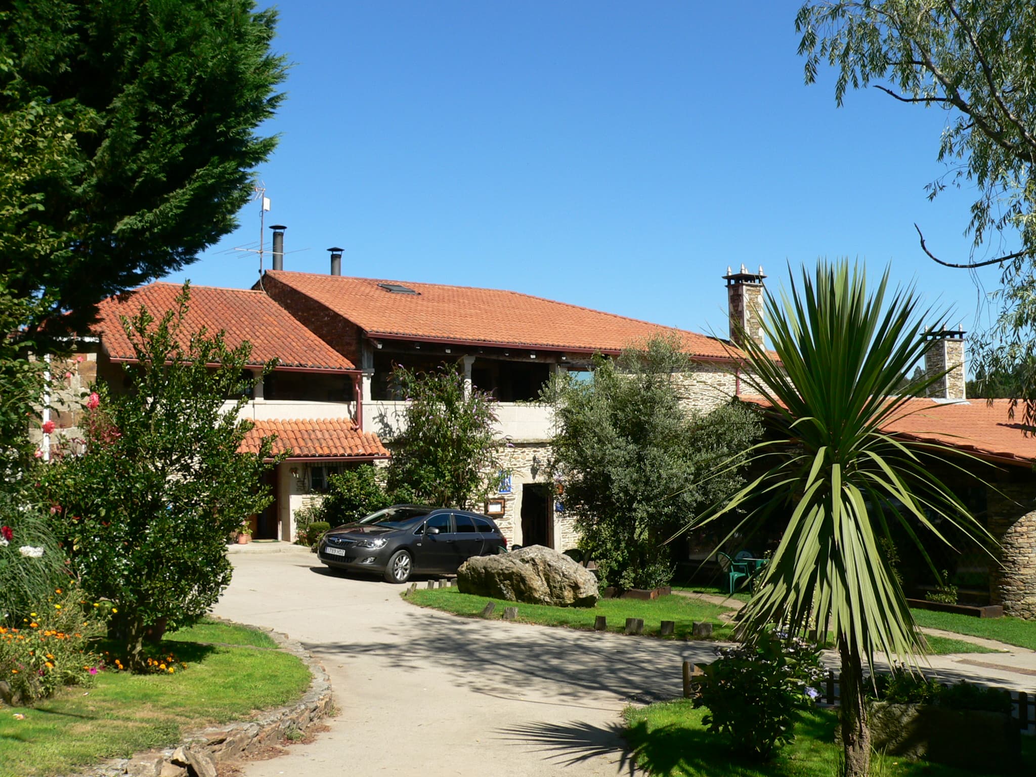 Fațada restaurantului Fogar de Breogán din Galicia, cu forme rotunjite și acoperiș din vegetație, inspirate din casele hobbiților