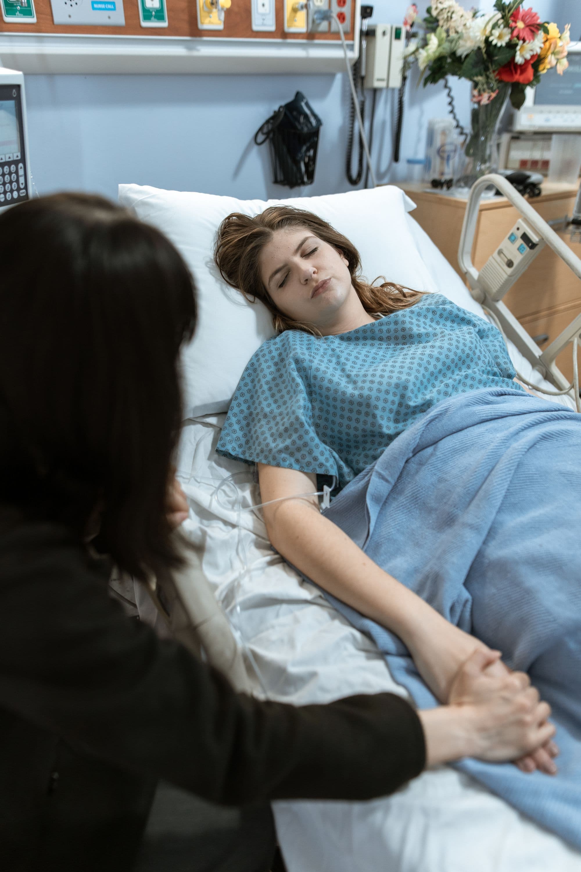 Pacientă vârstnică îngrijită la pat de spital, imagine ilustrativă — Anchetă în Gorj, după moartea unei adolescente de 14 ani