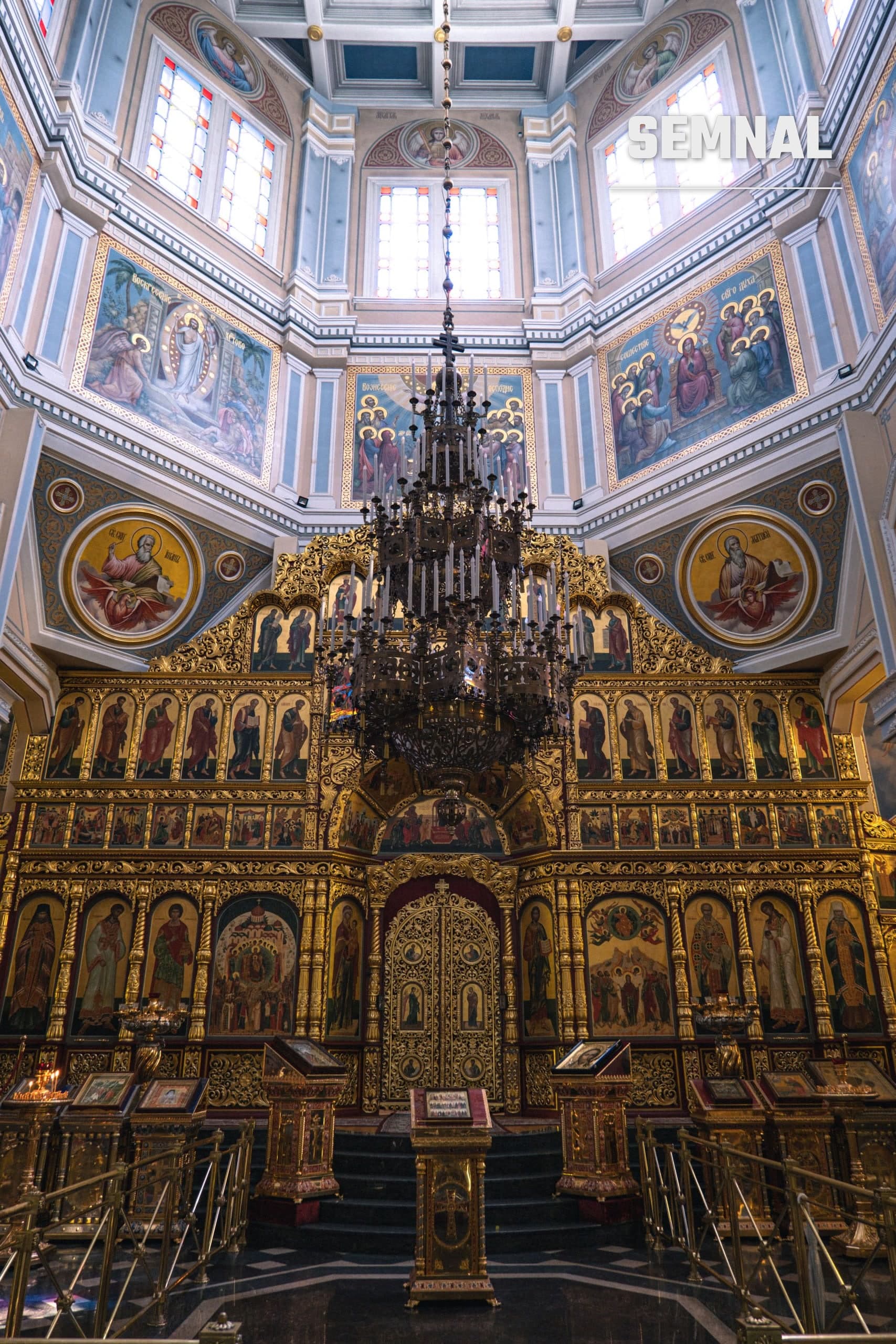 Interior de biserică ortodoxă cu iconostas aurit și candelabru, imagine ilustrativă
