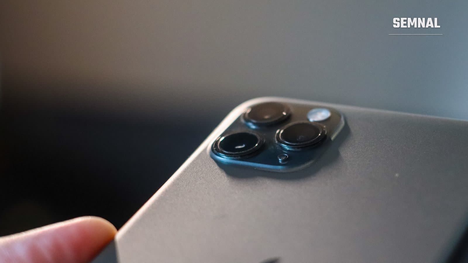 Prim-plan cu modulul de cameră triplă al unui telefon smartphone modern, cu lentilele așezate în decupaje circulare