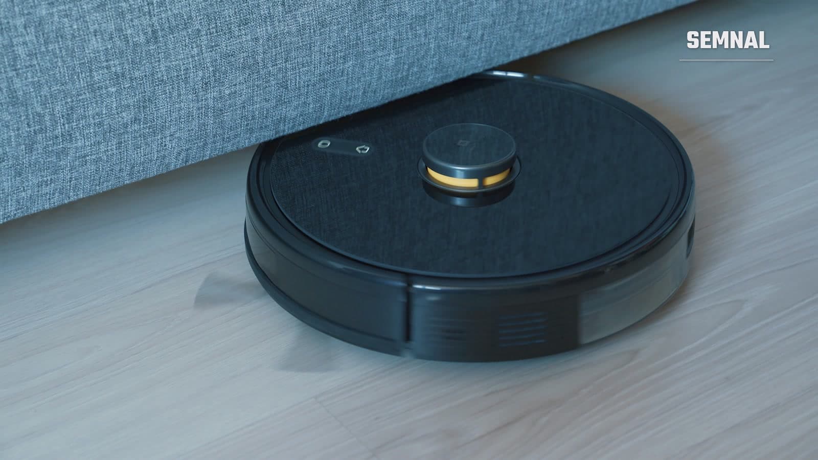 Aspirator robot negru pe podea din lemn, imagine cu caracter ilustrativ pentru un aspirator robot de tip flagship