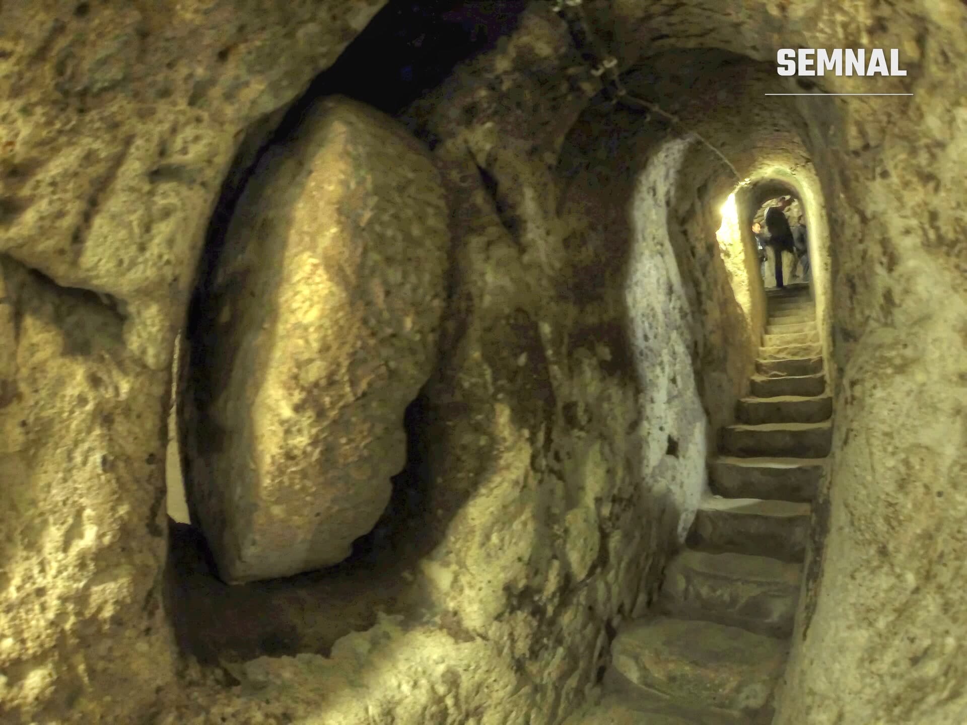 Ușă rotundă de piatră și scări sculptate într-un tunel din orașul subteran Derinkuyu, Cappadocia, Turcia