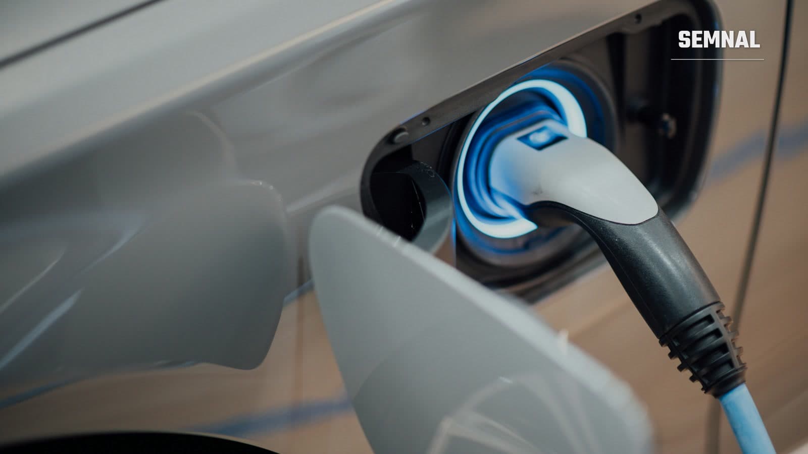 Cablu de încărcare conectat la o mașină electrică, cu conectorul introdus în portul de alimentare