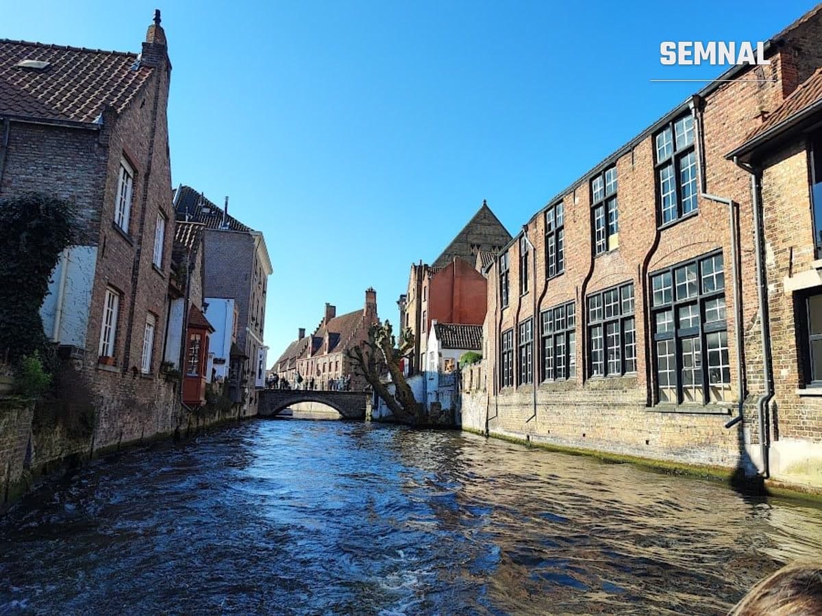 Case istorice din Bruges reflectate într-un canal, în lumina zilei