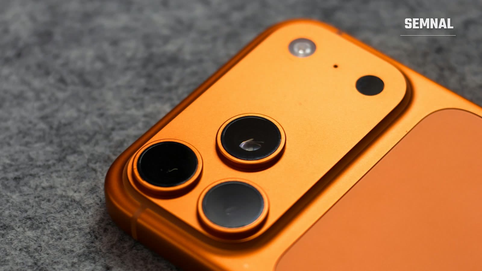 Prim-plan cu modulul de cameră triplă al unui smartphone modern, cu lentilele așezate în decupaje circulare
