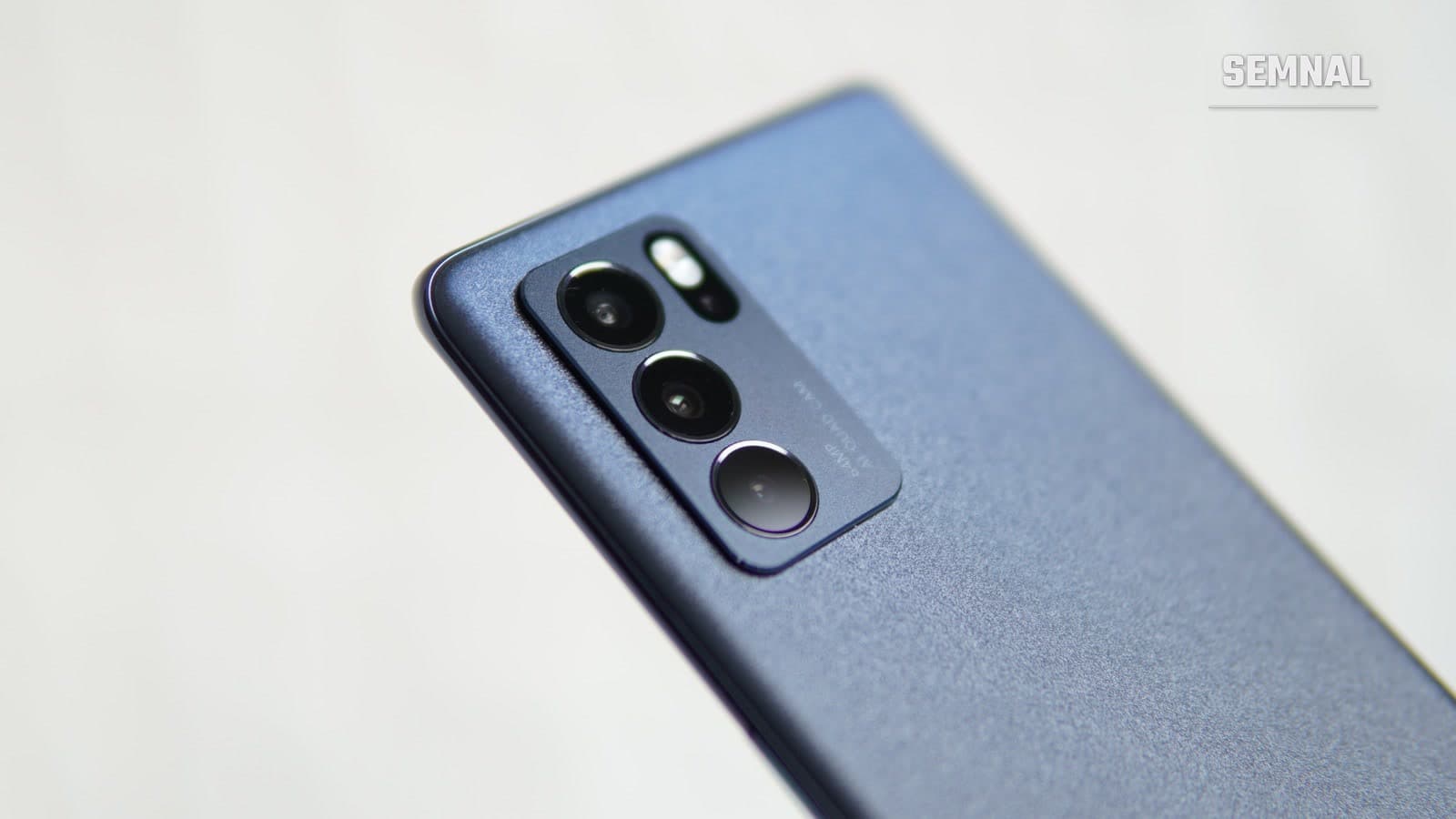 Prim-plan al modulului foto cu mai multe camere al unui telefon smartphone modern, ținut înclinat pe un fundal deschis