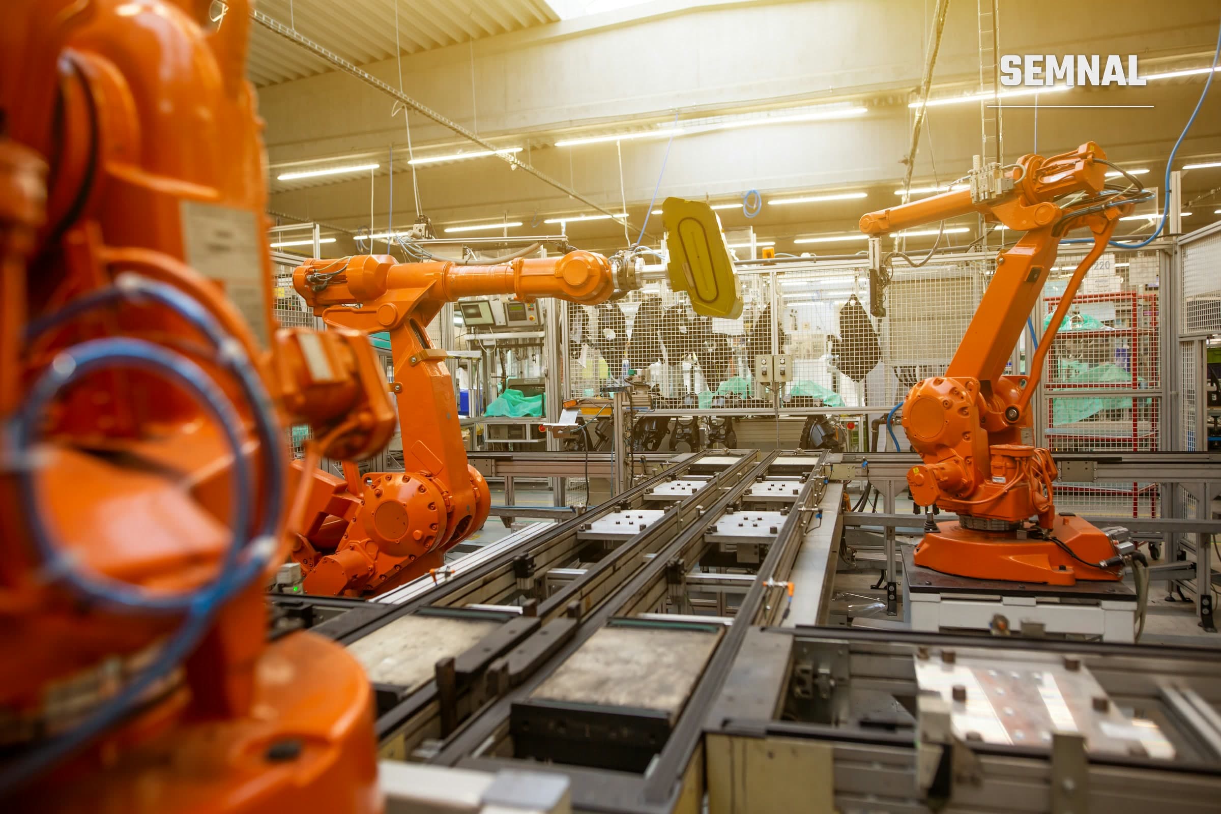 Robot industrial portocaliu pe o linie de asamblare într-o fabrică auto