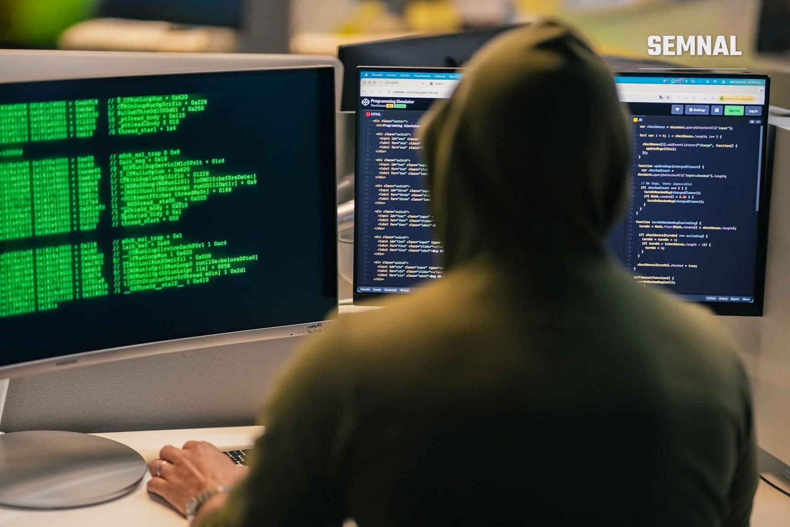 Ecrane de calculator cu linii de cod, într-o cameră întunecată, ilustrând un mediu de securitate cibernetică