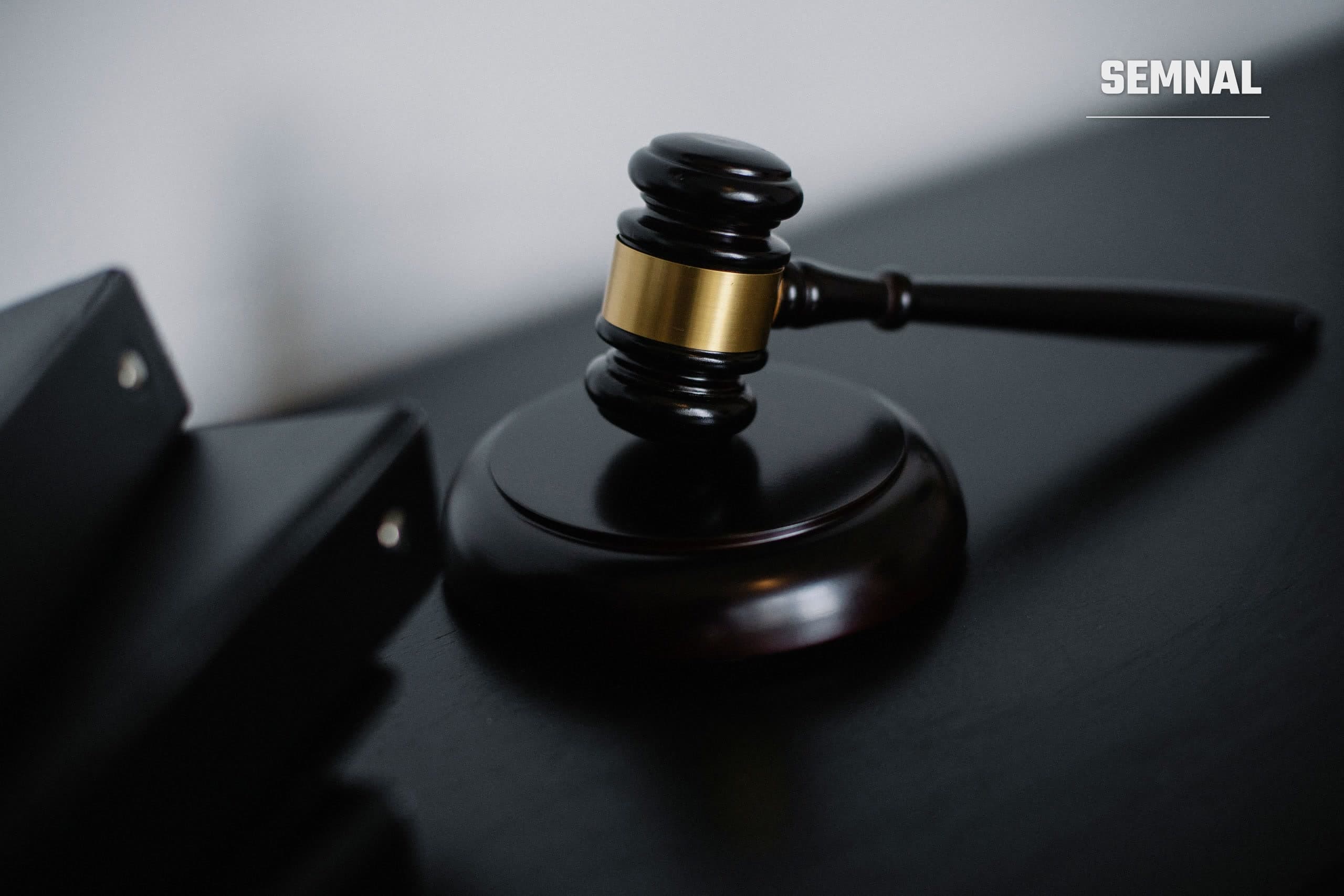 Ciocănel de judecător pe un birou, simbol al unui proces în instanță