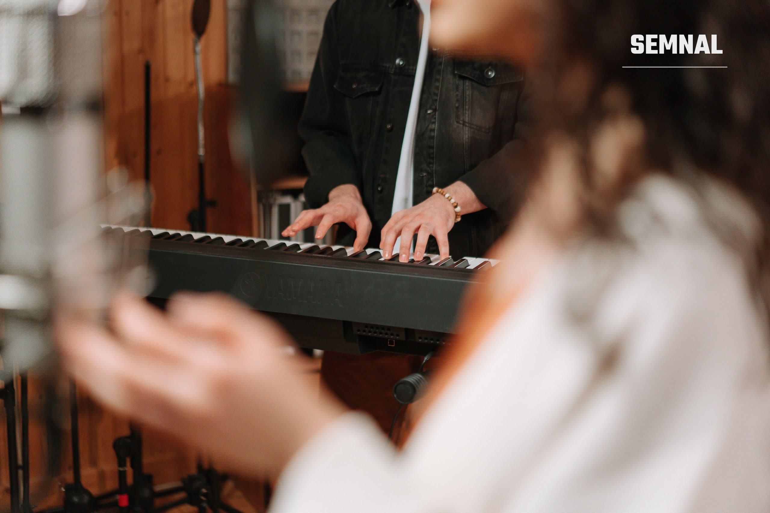 Mâini de pianist pe clapele unui pian, imagine ilustrativă