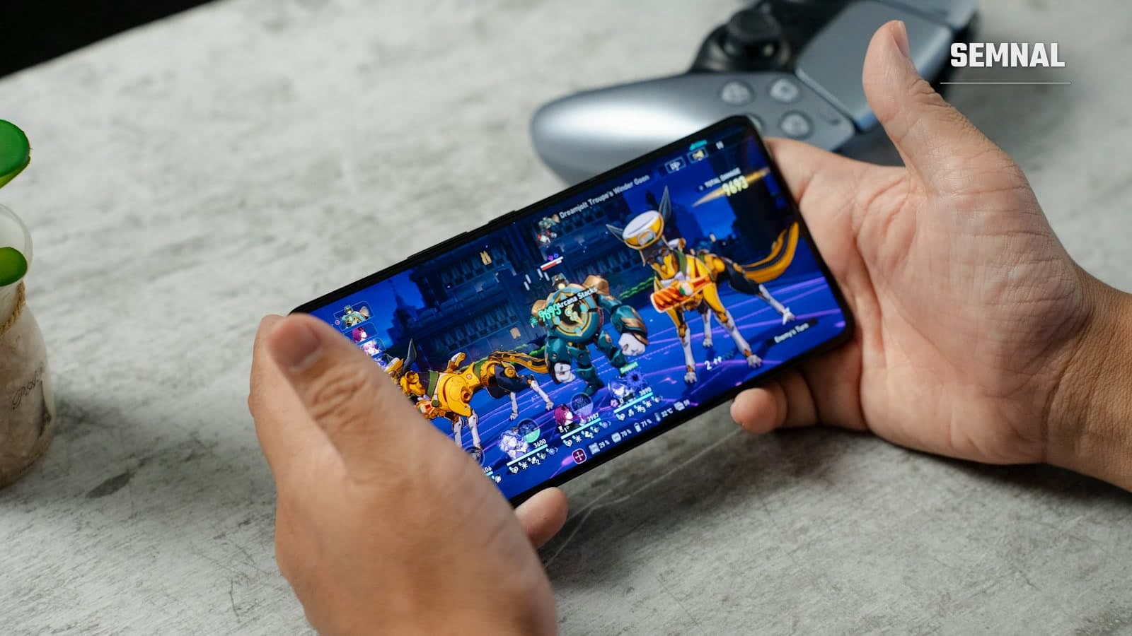 Telefon de gaming Asus ROG cu lumină albastră și mov, ținut în mână în timp ce rulează un joc video