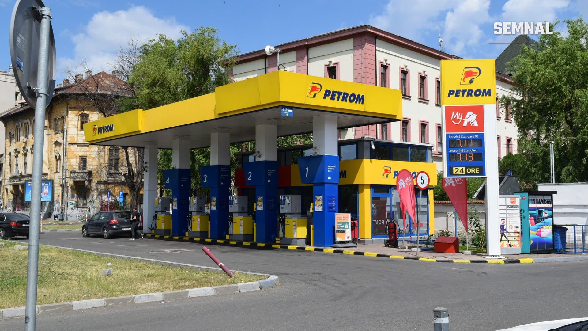 Stație de alimentare Petrom din București, cu copertină galbenă, pompe albastre și un panou cu prețurile carburanților