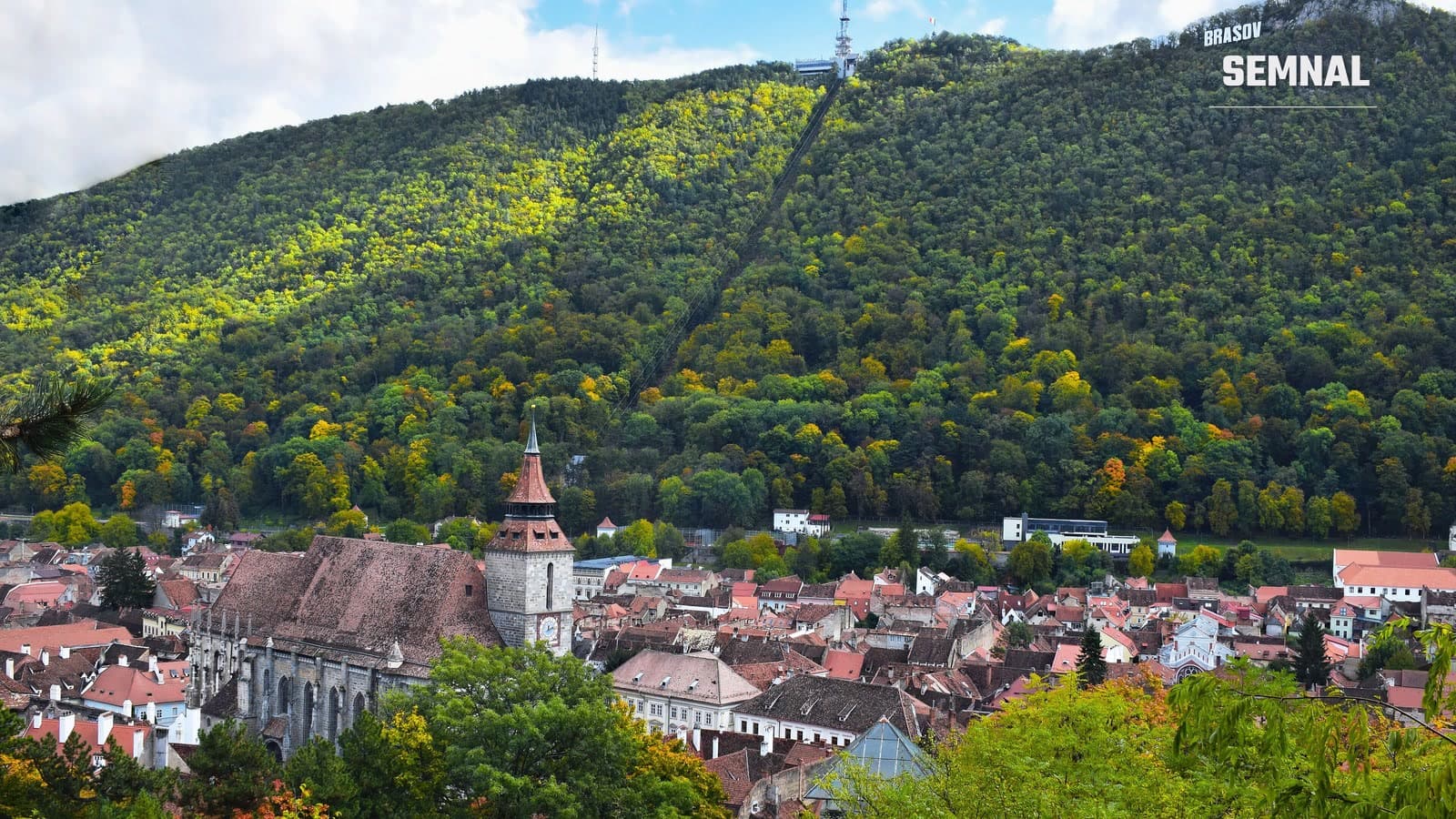 Centrul istoric al Brașovului, cu Biserica Neagră, și dealul Tâmpa acoperit de păduri în culorile toamnei