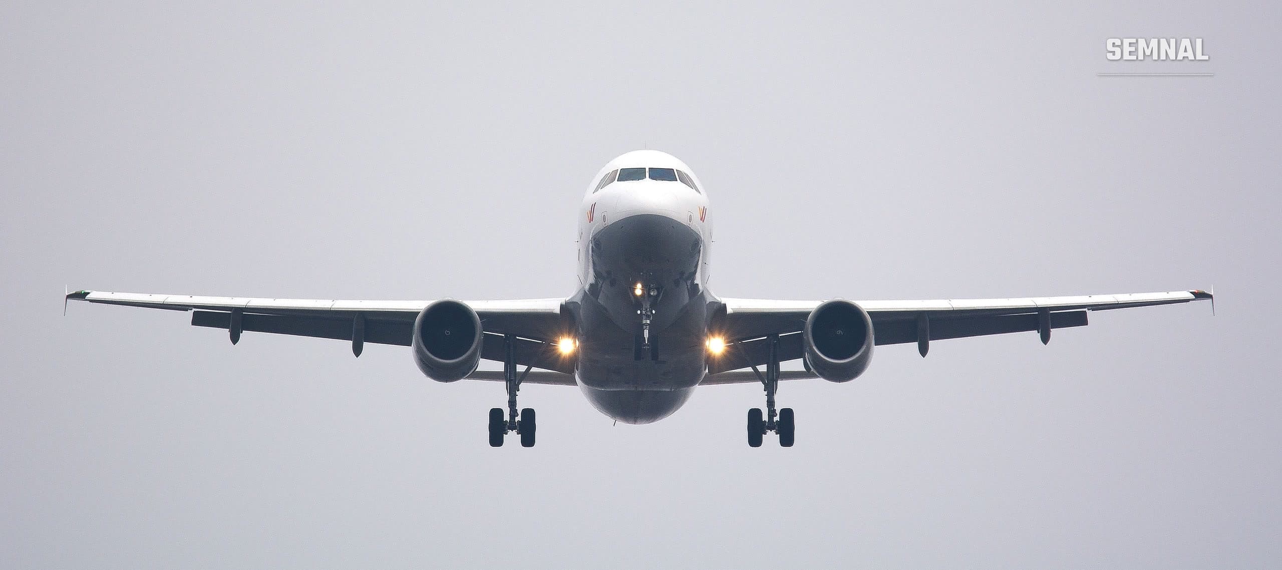 Imagine ilustrativă: avion de pasageri văzut din față, în apropierea aterizării, pe un cer înnorat