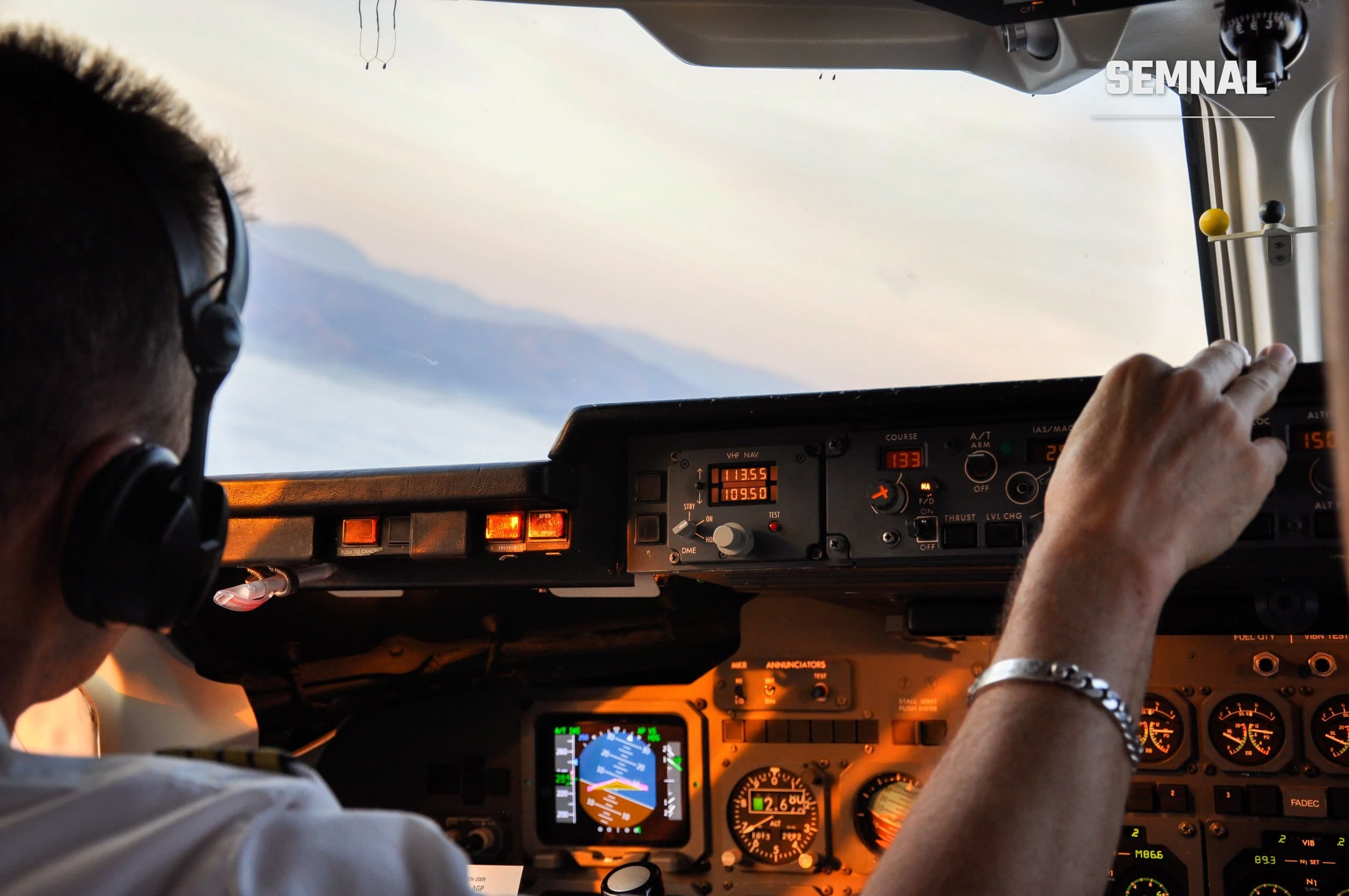 Pilot în cabina unui avion comercial, cu vedere spre instrumentele de zbor