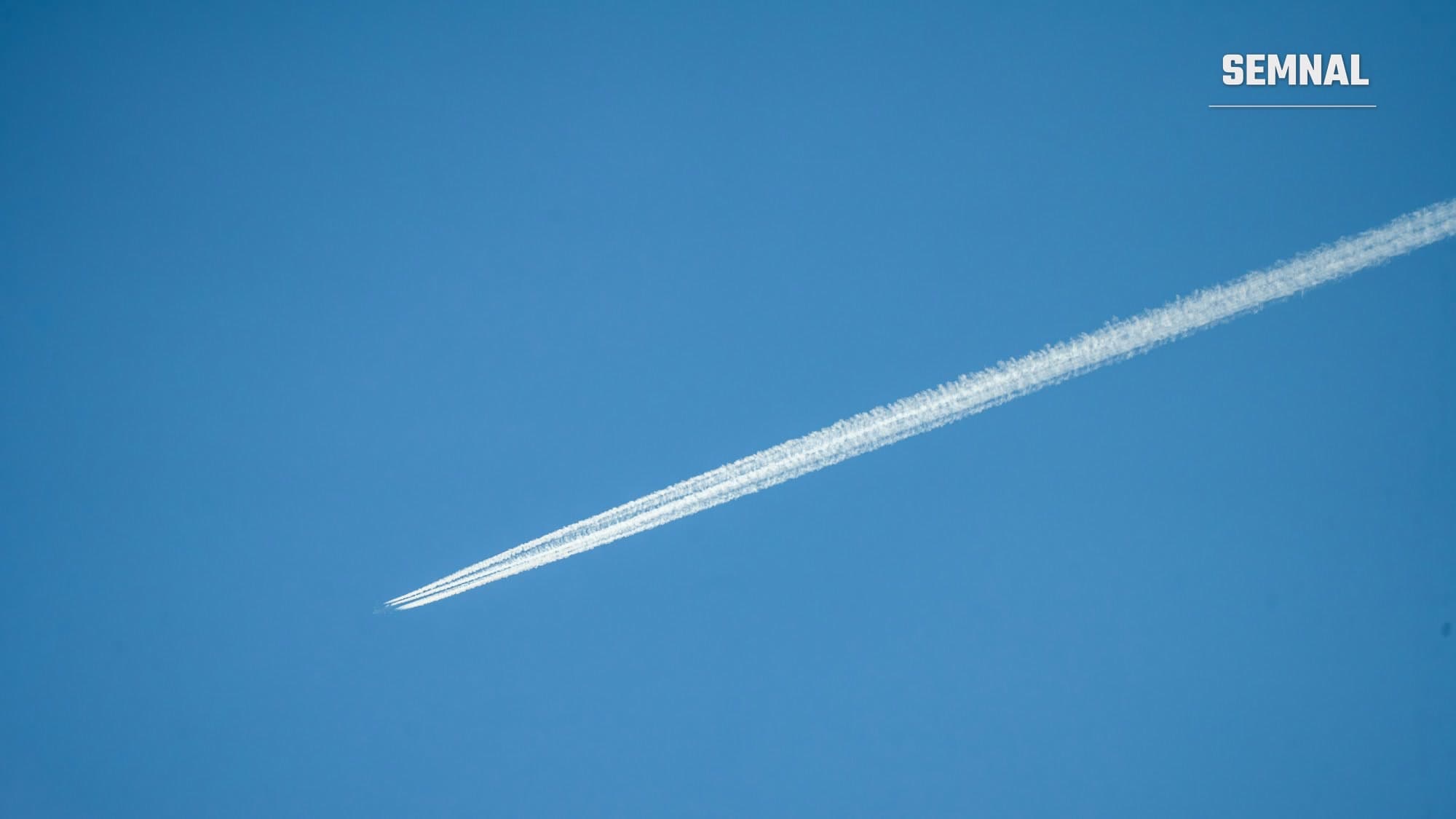 Dâră de condensare lăsată de un avion pe cer senin, imagine ilustrativă