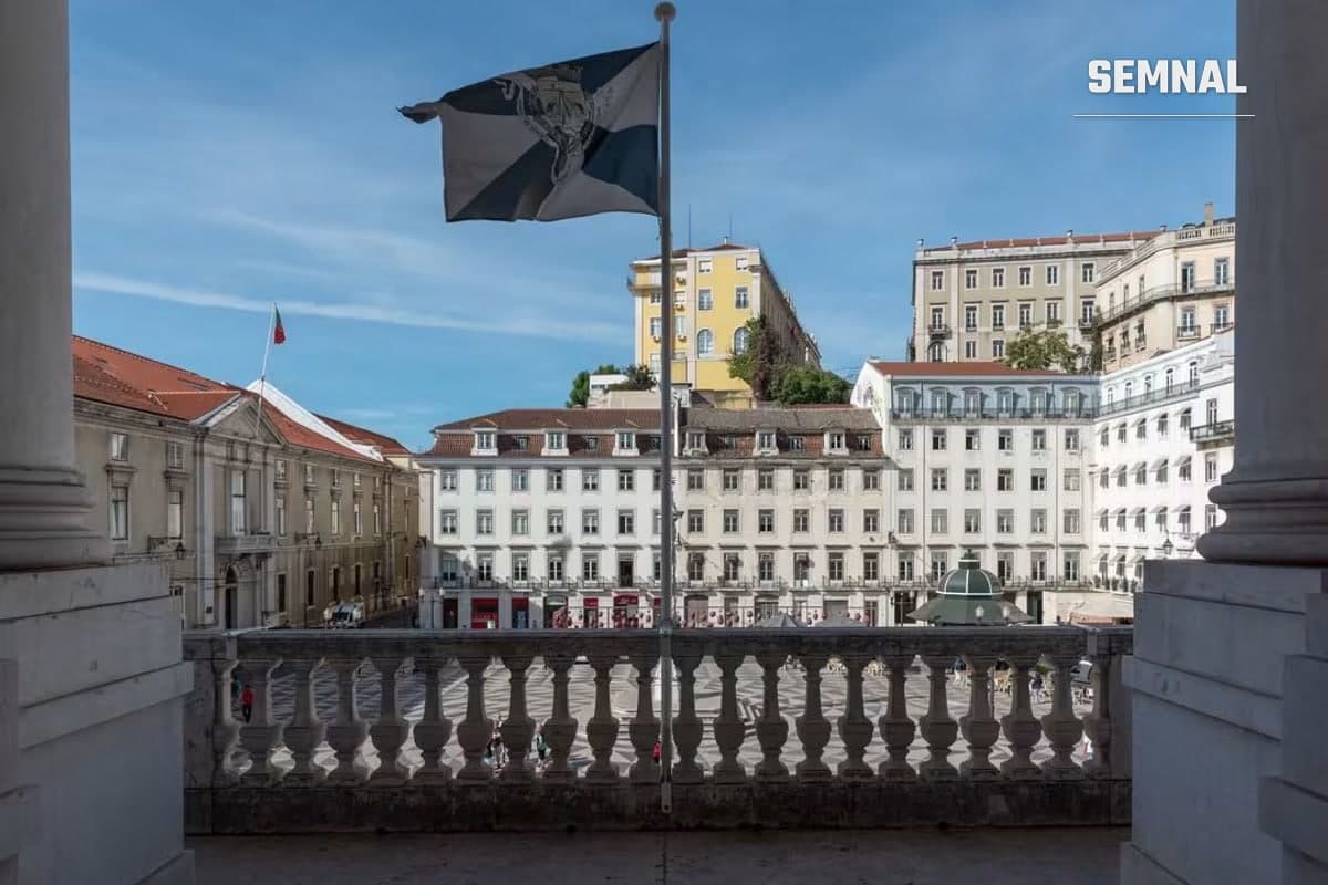Praça do Município din Lisabona văzută de la balconul Primăriei, cu drapelul alb-negru al orașului în prim-plan și drapelul Portugaliei pe o clădire din stânga (Foto: Câmara Municipal de Lisboa)