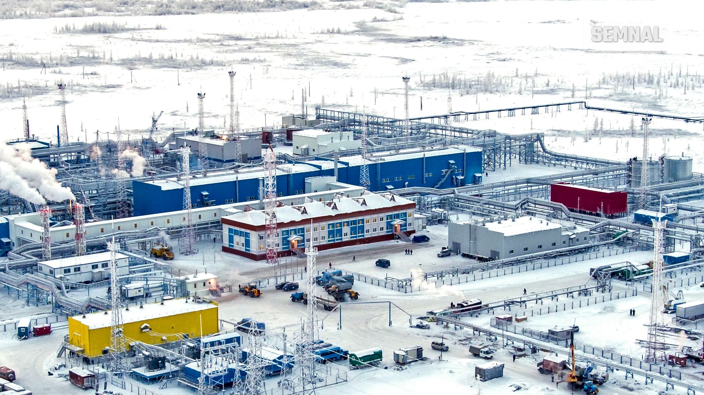 Vedere aeriană a instalațiilor de tratare a gazelor de la câmpul Zapolyarnoye, în nordul Siberiei, iarna, cu clădiri albastre și galbene pe zăpadă
