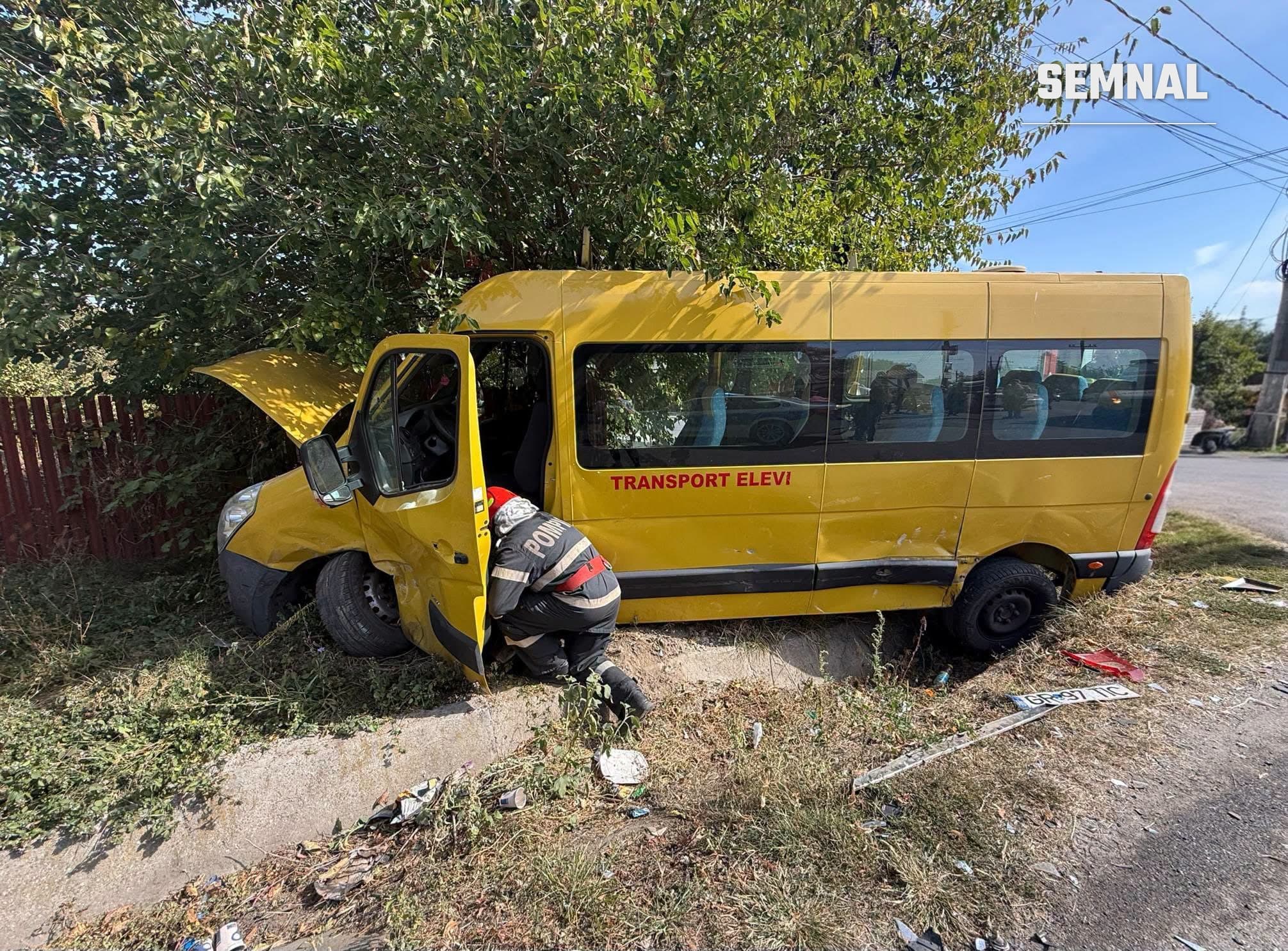 Pompier verifică microbuzul școlar galben ieșit în șanțul de lângă drum, după accidentul de la Singureni