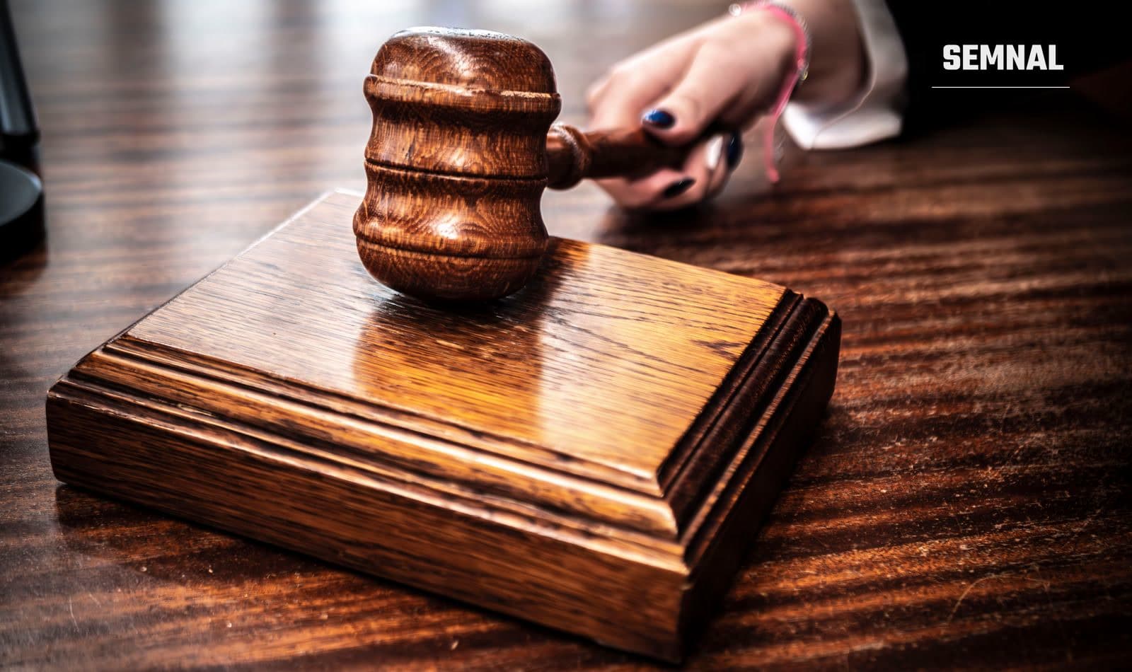 Ciocan de judecător pe un birou, într-o sală de judecată