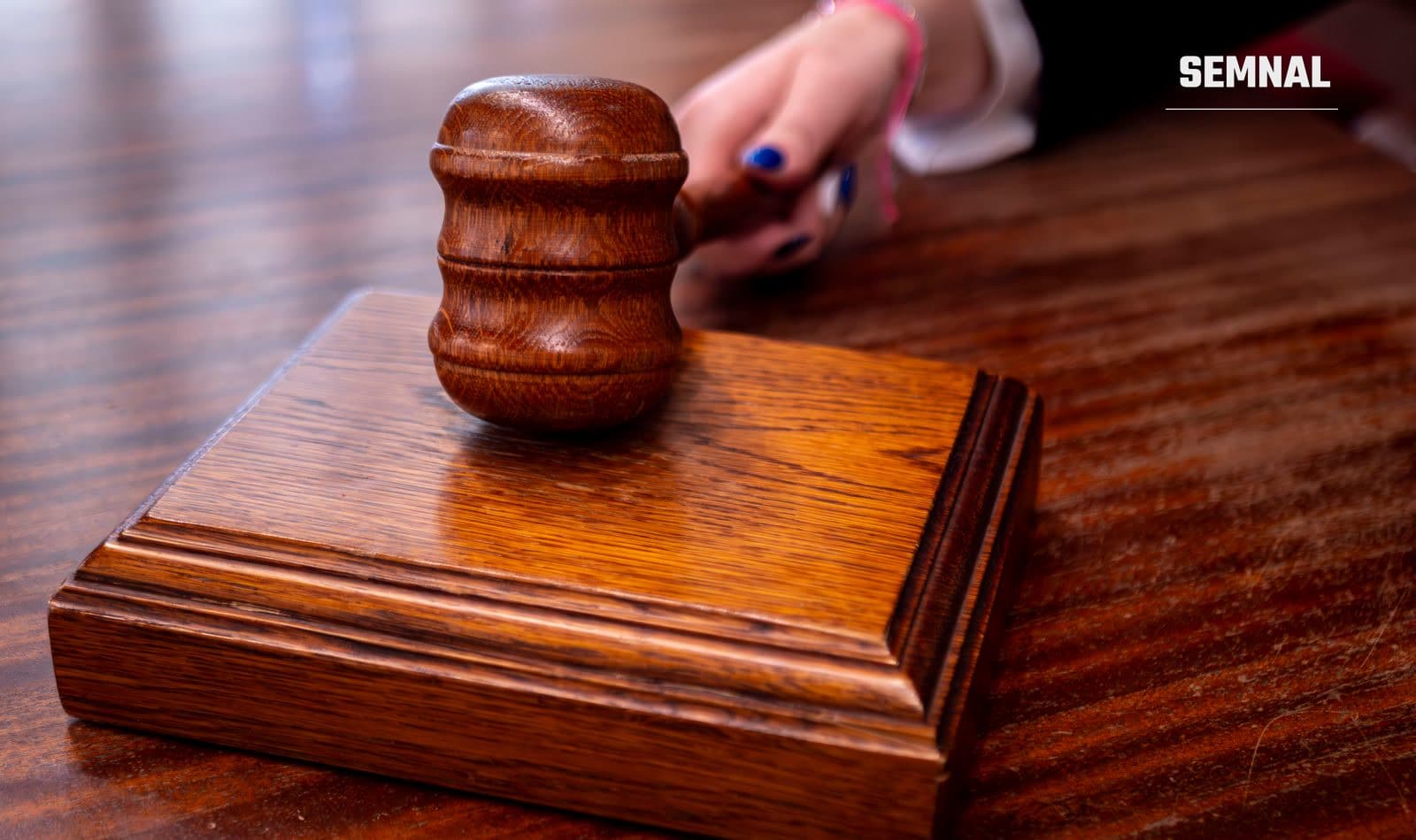 Ciocan de judecător pe un birou, într-o sală de judecată
