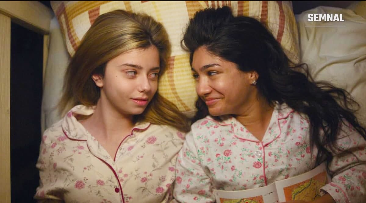 Două tinere întinse pe pat, în pijamale cu model floral, într-un cadru din filmul „Eu contez”