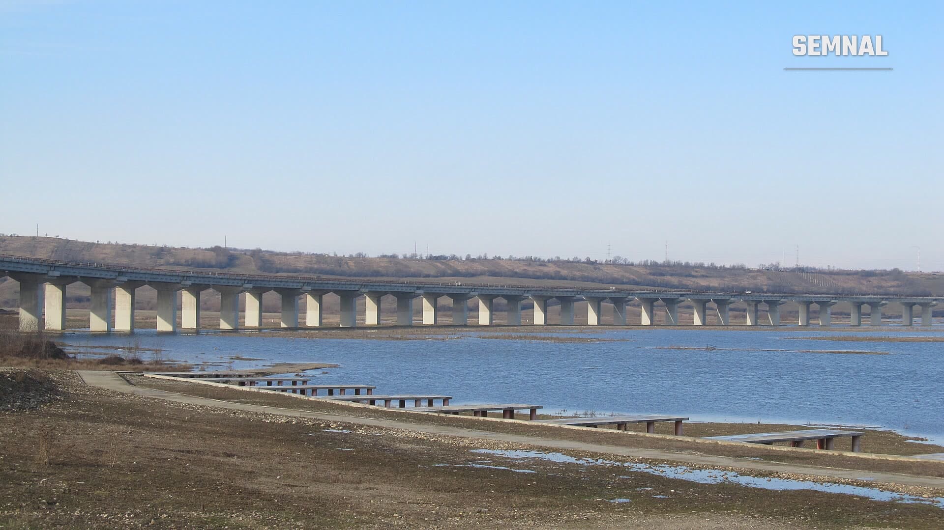 Viaduct lung din beton, cu piloni uniformi, pe Autostrada Transilvania (A3), lângă Suplacu de Barcău, peste o zonă inundată, sub un cer senin