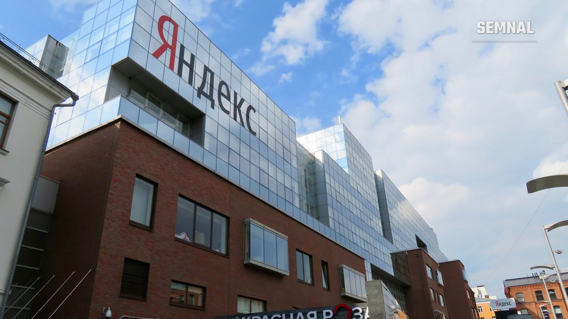 Fațada de sticlă și cărămidă a sediului Yandex din Moscova, cu sigla companiei pe acoperiș (Foto: WikiFido / Wikimedia Commons, CC BY-SA 4.0)